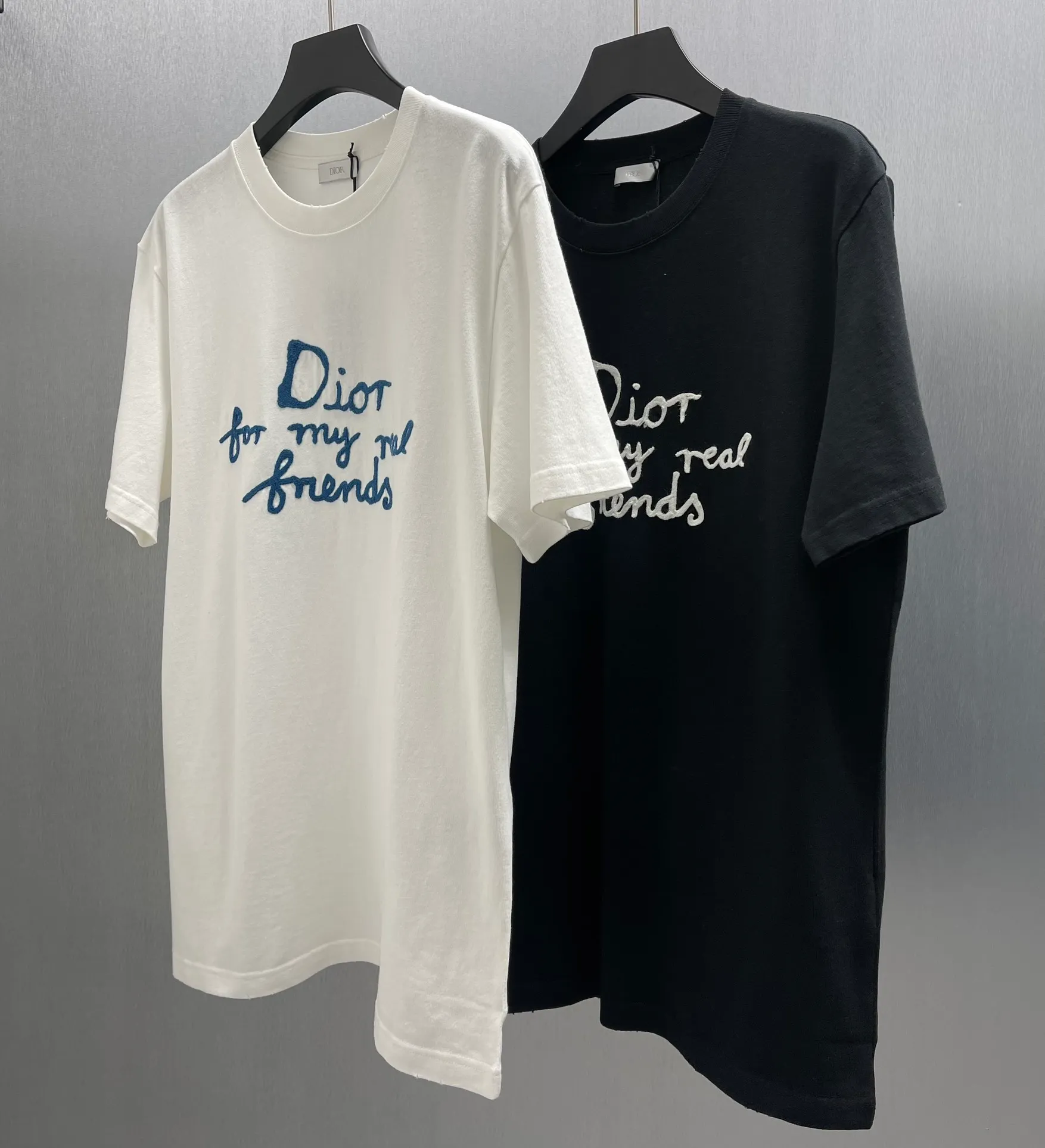 🅿️260 🧧CD True Friends Private Lettered Short Sleeves Size: S-XL This T-shirt displays the Dior For My Real Friends logo from the DIOR AND HYLTON NEL joint series. Crafted from black cotton jersey, it features a classic silhouette with a ribbed crew neck, embroidery on the chest for added style, and a burned-out effect on the collar, sleeves and hem. Cut for a relaxed fit, wear it with track pants or jeans.