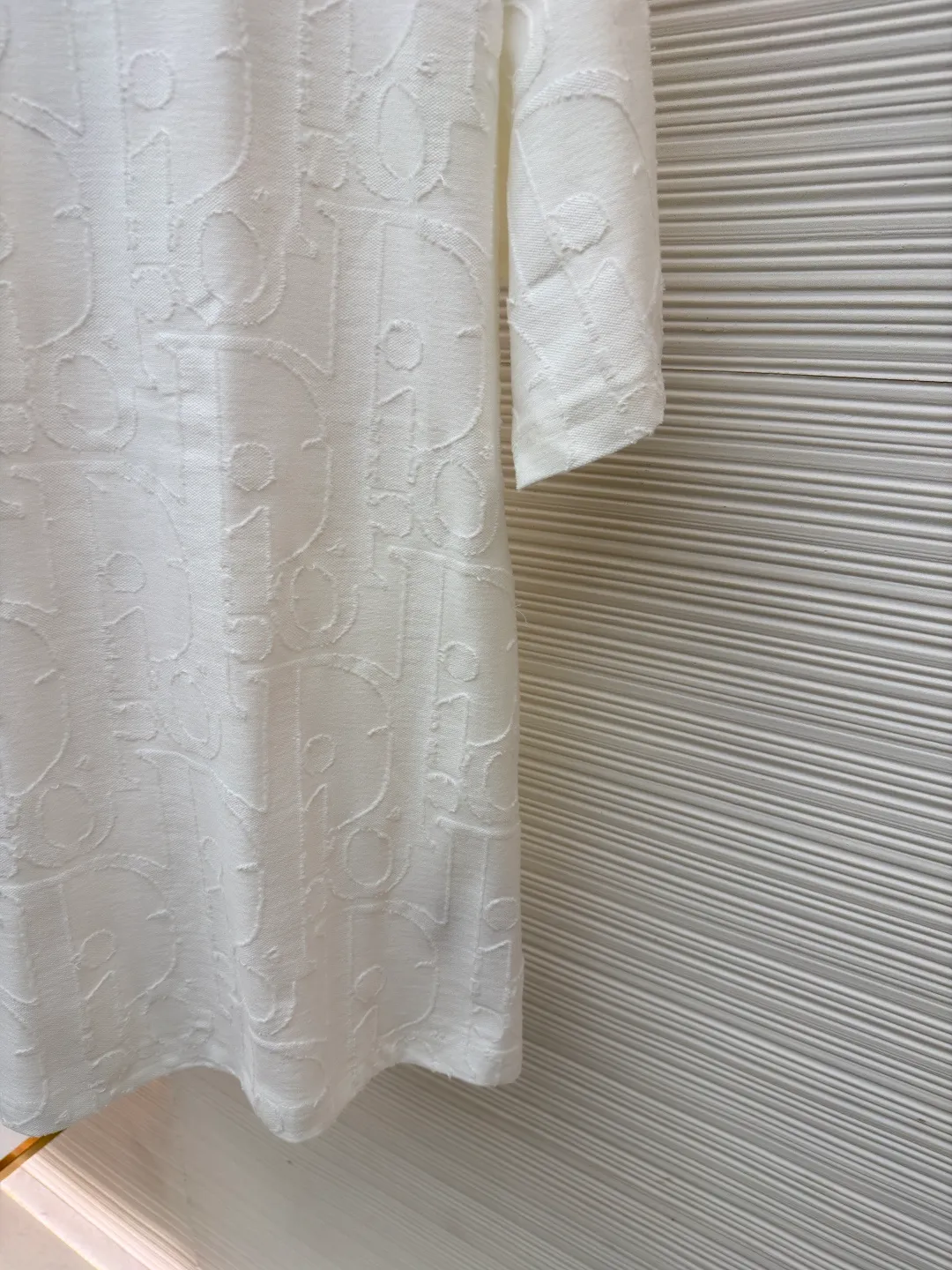 Dior cut-out embossed logo short sleeves ●Original version: Purchased and developed at 9100 ●Item number: 1682502-A05 ●Fabric: single yarn fabric ●Technology: fabric made by laser burning ●Color: white ●Type: fitted version ●Weight: about 280 grams ●Size: S-M-L-XL ●Description: 32-count single yarn fabric, the thread adopts 1*1 flat machine thread. The cloth is burned using laser. After the laser burning, the remaining raw edges need to be cut off manually. The original is scanned to develop a 1:1 pattern, and every size and position is consistent with the original. This T-shirt is new to the 2025 fall men's collection and is decorated with the classic Oblique print. Crafted from dark blue cotton-jersey, it's finished with an all-over cut-jacquard Oblique print. Pair with a variety of jeans for a casual look. Round neck with Oblique print. The overall wiring is straight and delicate, the fabric is comfortable and soft, and the color is consistent without color difference. It can be matched with the same style to create a fashionable look and control various occasions. Customized accessories, complete with three standards, same style for men and women!