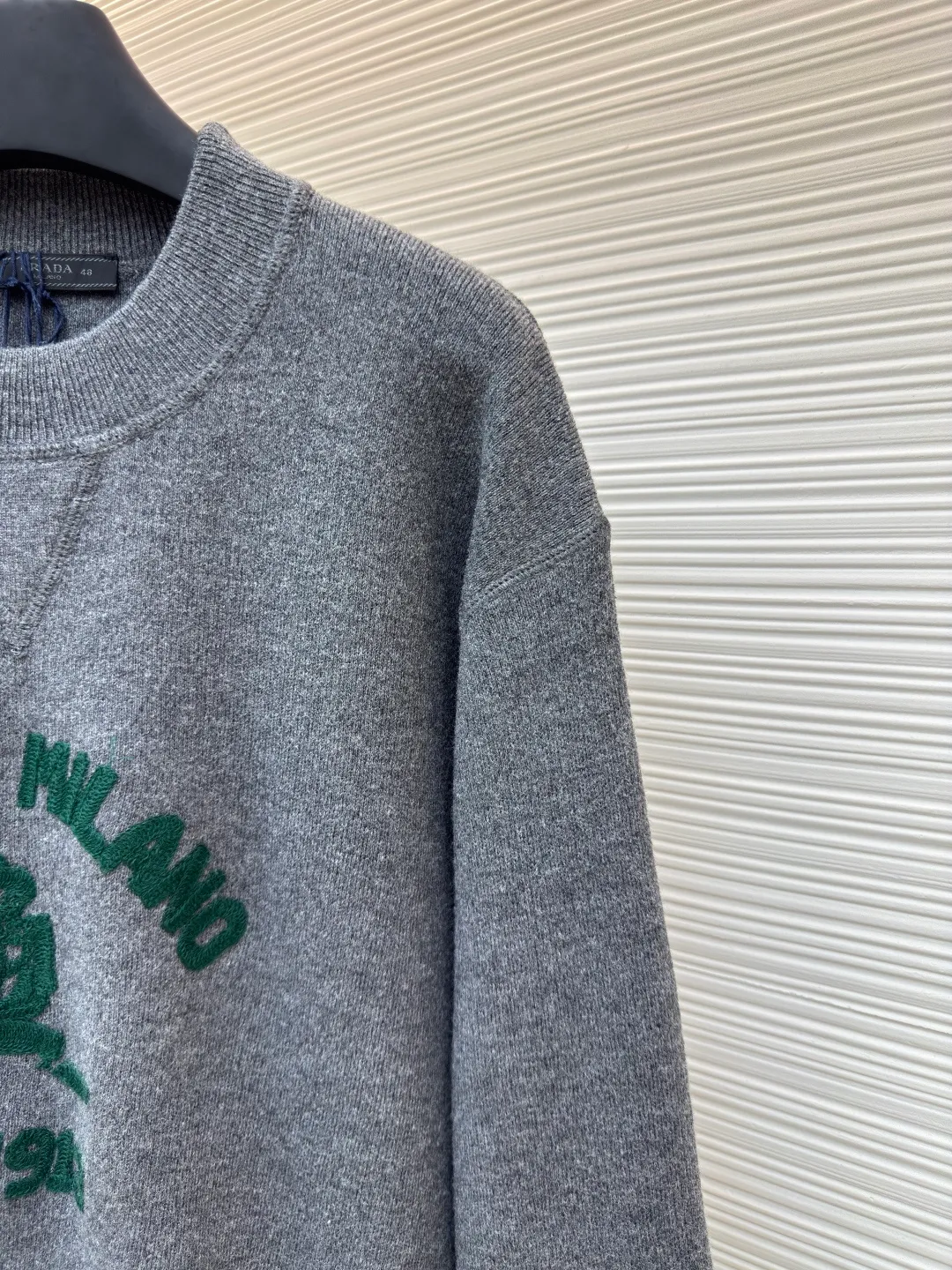 Prada music logo embroidered knitted sweater ●Article number: 1680706-A85 ●Fabric: Jersey knitted fabric ●Technology: Knitted embroidery production ●Version: Fitted version ●Weight: about 560 grams ●Size: S-M-L-XL ●Description: The "V-shaped design thread" on the neckline is by no means an ordinary stitch, but a functional and decorative craft. The highlight of chain-style towel embroidery is the special embroidery technique, which uses repeated chain stitches to form a continuous, raised towel-like coil effect pattern that appears on the cloth with a strong three-dimensional effect, soft and fluffy to the touch, and highly recognizable. It presents a terry-like texture, forming an interesting contrast with the smooth underside of the sweater, enriching the visual and tactile layers. The chain structure makes the embroidery not easy to snag or fall off, and has good durability. The collar, cuffs and hem are all ribbed; the excellent lateral elasticity of the ribbed tissue not only ensures that the key parts of the body are firm and not easily deformed, durable and washable, but can also be tightened naturally to outline a neat outline. Its functionality and decoration coexist: it not only prevents the intrusion of cold wind and improves thermal insulation efficiency, but also adds a sense of rhythm in details to the overall simple design, making the shape more crisp. The overall wiring is straight and delicate, the fabric is comfortable and soft, and the color is consistent without color difference. It can be matched with the same style to create a fashionable look and control various occasions. Customized accessories, complete with three standards, same style for men and women!