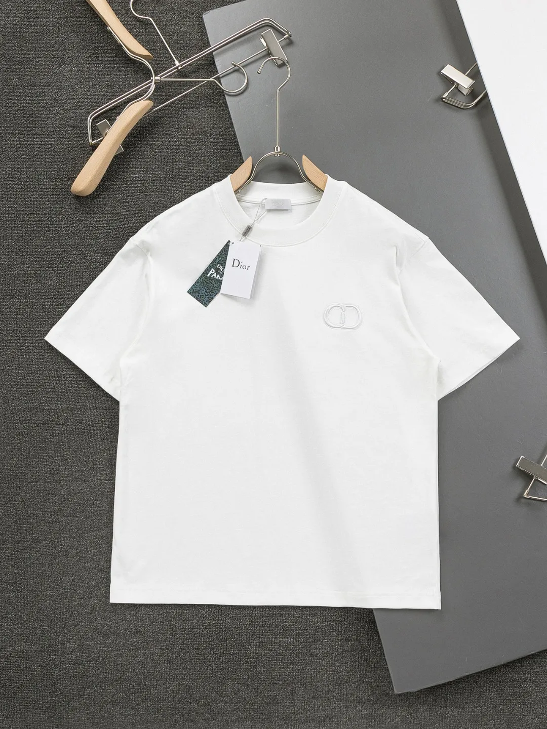 🅿️190 Dior Dior micro wide version CD micro wide version S-XL 26ss new product counter timeless classic CD letter embroidery🪡logo pattern As the leader in the luxury world, the D family is well-deserved. The first thing that catches the eye is the loose and comfortable black and white solid color version of the piece we are going to talk about today. The ribbed round collar has become the best modification of its version, and the D family has the upper body LOGO listed on the front, and the unique embroidery design of the letter logo patch highlights the texture! The most traditional modification method combined with the simplest color scale contrast forms the strongest and direct contrast, and this is often the most concise and clear minimalist modification method~~A nostalgic classic atmosphere also spreads in this work inadvertently! ! Featuring a distinctive 47 logo patch embroidery on the front, a unique tribute to Dior's historic year! Coupled with the blessing of 320 grams of cotton material, both the upper body comfort and the existence are unparalleled. It can be said to be a must-have companion in summer. The excellent breathability and comfortable wearing feeling are unparalleled~ Recommended! ! Color: Black White Blue Size: S-XL Size chart: S: Shoulder width 55-Bust 56-Length 71.5 M: Shoulder width 56.5-Bust 58-Length 73 L: Shoulder width 58-Bust 60-Length 74.5 XL: Shoulder width 59.5-Bust 62-Length 76