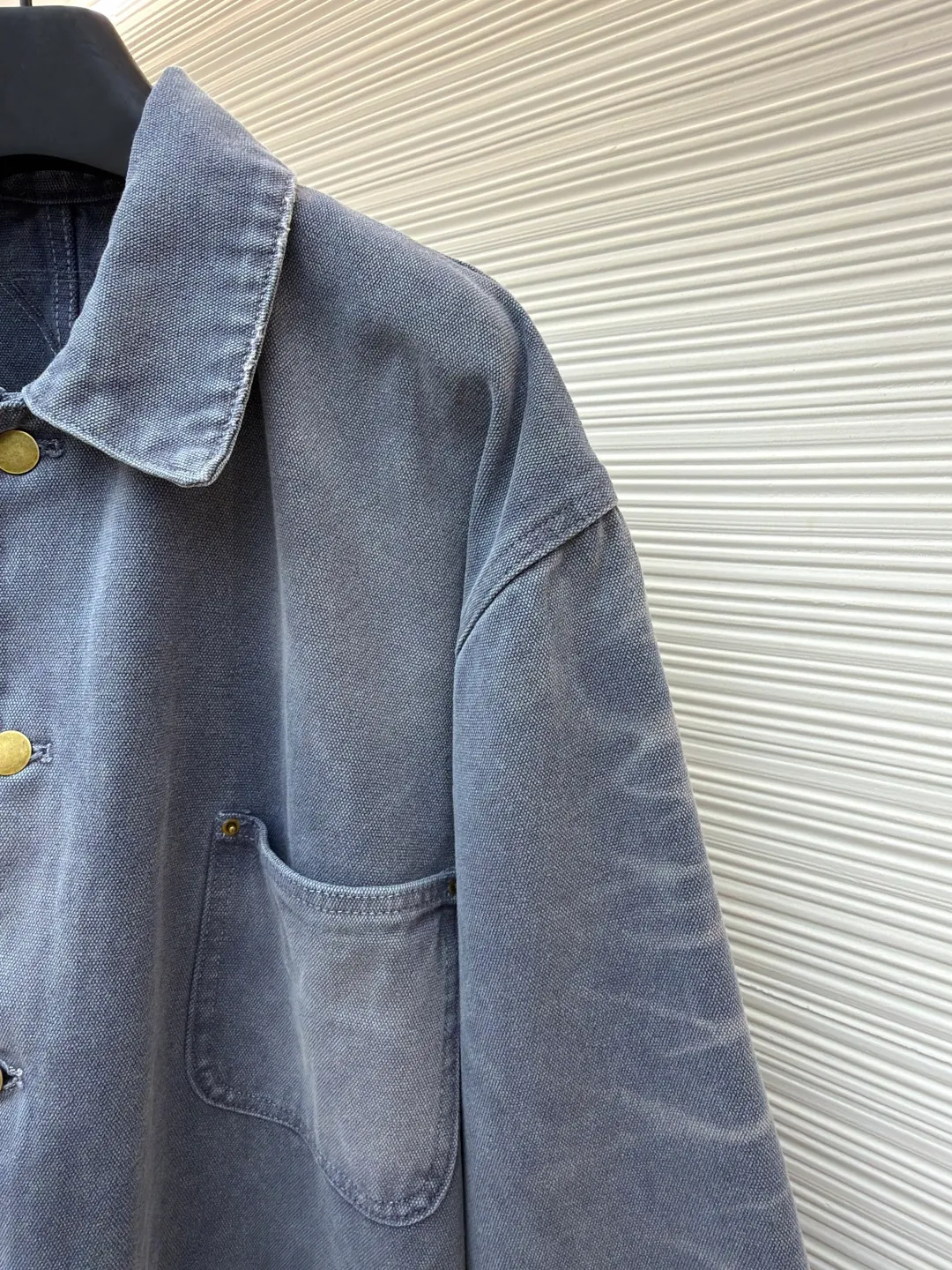 Prada distressed ice blue four-pocket work jacket ●Original version: purchased and developed by 15761 ●Item number: 1681562-B20 ●Fabric: cotton canvas fabric ●Technology: made with distressed wash ●Color: ice blue ●Version: fitted version ●Weight: about 1185 grams ●Size: S-M-L ●Description: Made of high-weight cotton canvas, specially tanned and pre-shrunk to ensure a stiff silhouette while improving durability. It adopts multi-stage artificial wear technology, including sandpaper polishing, enzyme washing and fading, and edge tearing treatment to form a natural fading gradient in stress areas such as collars, cuffs, and hems, simulating the retro traces of long-term wear.  A matte resin coating is applied to the surface, which not only retains the rough texture of the canvas, but also enhances windproof and anti-fouling properties, embodying Prada's "functional luxury" concept. The main stitching uses luxury-grade 20/3-strand high-twist thread, while the decorative topstitching is replaced with 0.1mm ultra-fine polyester thread, creating a visual contrast between fragility and solidity.  Customized distressed matte hardware accessories, with the PRADA dark pattern logo engraved on the bottom, implementing the "unfinished" design philosophy. This jacket is essentially a sophisticated game of materials - deconstructing workwear prototypes with the precision engineering of high fashion, and reconstructing the value narrative with anti-luxury old-fashioned techniques, fully presenting the concept of "Imperfect Sublime" proposed by Miuccia Prada. The overall wiring is straight and delicate, the fabric is comfortable and soft, and the color is consistent without color difference. It can be matched with the same style to create a fashionable look and control various occasions. Customized accessories, complete with three standards, same style for men and women!