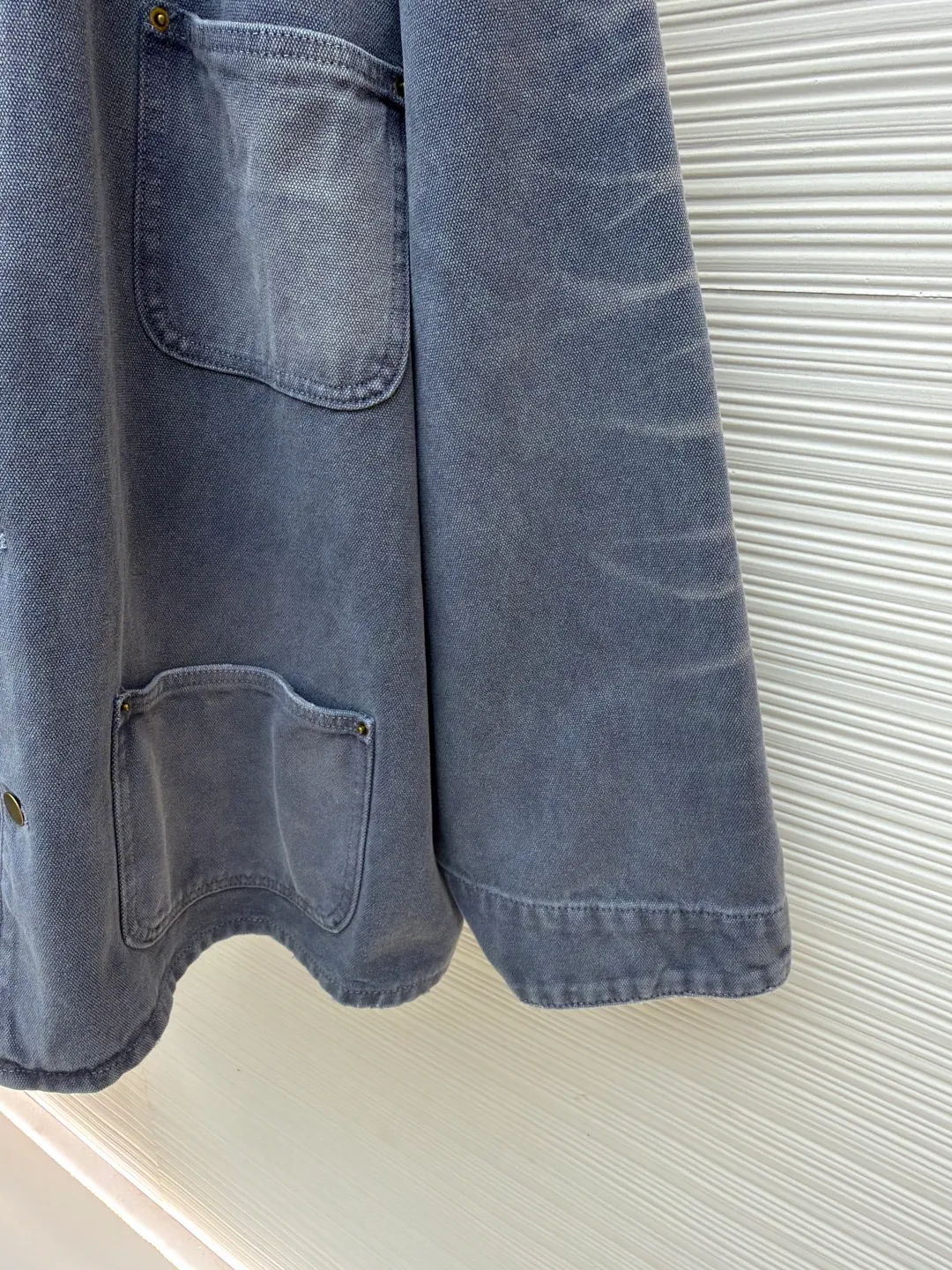 Prada distressed ice blue four-pocket work jacket ●Original version: purchased and developed by 15761 ●Item number: 1681562-B20 ●Fabric: cotton canvas fabric ●Technology: made with distressed wash ●Color: ice blue ●Version: fitted version ●Weight: about 1185 grams ●Size: S-M-L ●Description: Made of high-weight cotton canvas, specially tanned and pre-shrunk to ensure a stiff silhouette while improving durability. It adopts multi-stage artificial wear technology, including sandpaper polishing, enzyme washing and fading, and edge tearing treatment to form a natural fading gradient in stress areas such as collars, cuffs, and hems, simulating the retro traces of long-term wear.  A matte resin coating is applied to the surface, which not only retains the rough texture of the canvas, but also enhances windproof and anti-fouling properties, embodying Prada's "functional luxury" concept. The main stitching uses luxury-grade 20/3-strand high-twist thread, while the decorative topstitching is replaced with 0.1mm ultra-fine polyester thread, creating a visual contrast between fragility and solidity.  Customized distressed matte hardware accessories, with the PRADA dark pattern logo engraved on the bottom, implementing the "unfinished" design philosophy. This jacket is essentially a sophisticated game of materials - deconstructing workwear prototypes with the precision engineering of high fashion, and reconstructing the value narrative with anti-luxury old-fashioned techniques, fully presenting the concept of "Imperfect Sublime" proposed by Miuccia Prada. The overall wiring is straight and delicate, the fabric is comfortable and soft, and the color is consistent without color difference. It can be matched with the same style to create a fashionable look and control various occasions. Customized accessories, complete with three standards, same style for men and women!