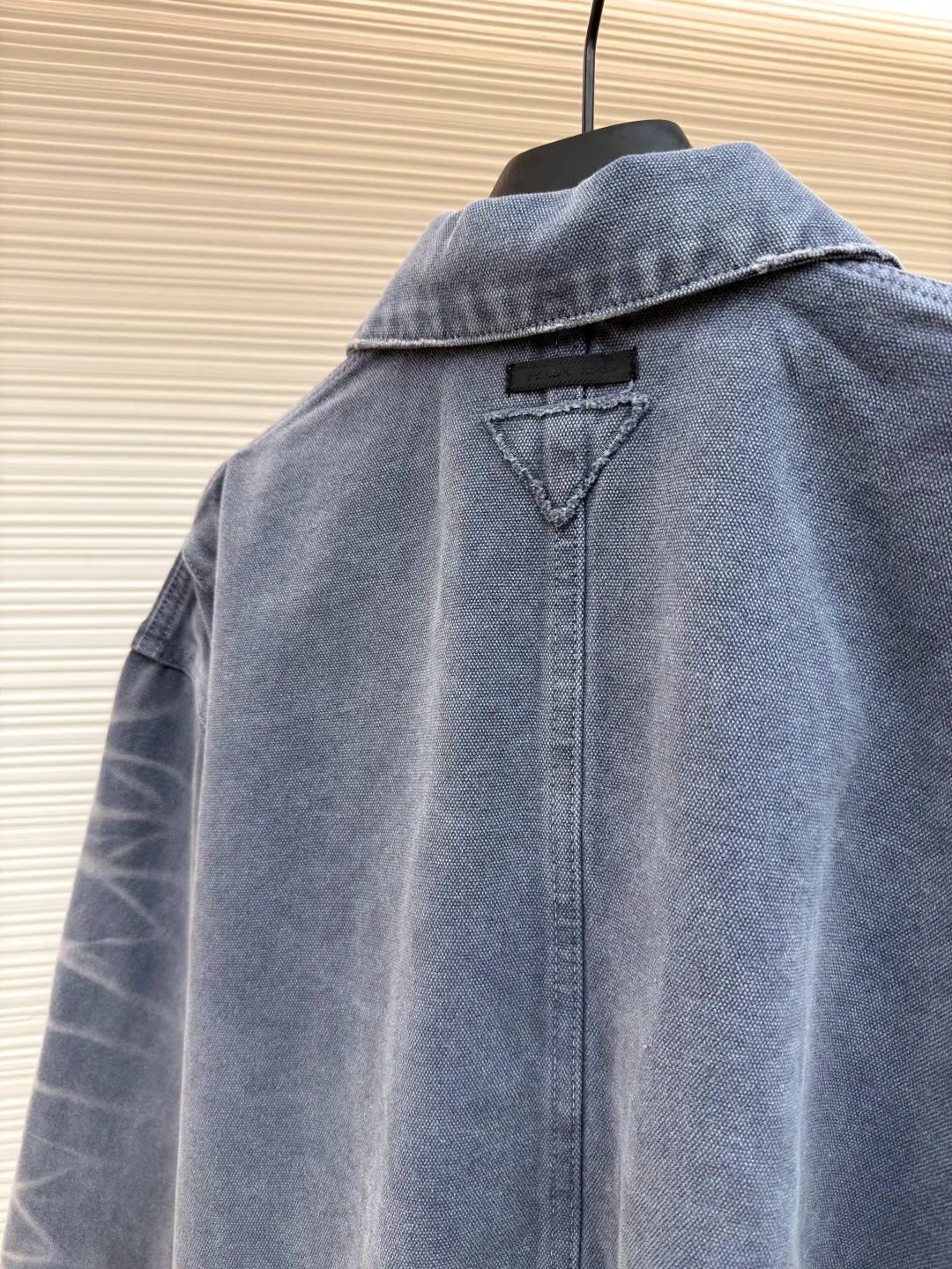 Prada distressed ice blue four-pocket work jacket ●Original version: purchased and developed by 15761 ●Item number: 1681562-B20 ●Fabric: cotton canvas fabric ●Technology: made with distressed wash ●Color: ice blue ●Version: fitted version ●Weight: about 1185 grams ●Size: S-M-L ●Description: Made of high-weight cotton canvas, specially tanned and pre-shrunk to ensure a stiff silhouette while improving durability. It adopts multi-stage artificial wear technology, including sandpaper polishing, enzyme washing and fading, and edge tearing treatment to form a natural fading gradient in stress areas such as collars, cuffs, and hems, simulating the retro traces of long-term wear.  A matte resin coating is applied to the surface, which not only retains the rough texture of the canvas, but also enhances windproof and anti-fouling properties, embodying Prada's "functional luxury" concept. The main stitching uses luxury-grade 20/3-strand high-twist thread, while the decorative topstitching is replaced with 0.1mm ultra-fine polyester thread, creating a visual contrast between fragility and solidity.  Customized distressed matte hardware accessories, with the PRADA dark pattern logo engraved on the bottom, implementing the "unfinished" design philosophy. This jacket is essentially a sophisticated game of materials - deconstructing workwear prototypes with the precision engineering of high fashion, and reconstructing the value narrative with anti-luxury old-fashioned techniques, fully presenting the concept of "Imperfect Sublime" proposed by Miuccia Prada. The overall wiring is straight and delicate, the fabric is comfortable and soft, and the color is consistent without color difference. It can be matched with the same style to create a fashionable look and control various occasions. Customized accessories, complete with three standards, same style for men and women!