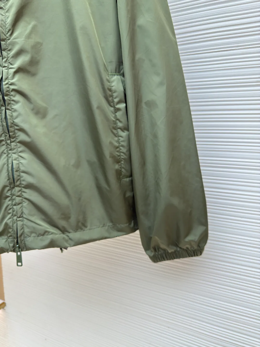 Prada functional zipper jacket ●Authentic product: Purchased and developed for 16700 ●Item number: 1680566-B20 ●Fabric: nylon fabric ●Technology: Positioning cutting machine ●Version: fitted version ●Weight: about 310 grams ●Size: S-M-L-XL ●Description: Customized and elegant light and strong regenerated nylon silk, as light as feathers, comfortable and close to the skin, with olive green as the main color, occupying a place with its unique calmness and elegance The tailoring is neat and generous, the lines are smooth and natural, the exquisite triangle logo on the side blooms the brand charm, simple yet elegant, the hood flutters gently, adding a sense of agility and elegance to the overall shape. With its unique flexible switching design of the clothing bag, it has become a model of the perfect integration of fashion and function. The custom pattern template machine is sewn. The sewing line is precisely controlled by the pattern machine to ensure the precise positioning of the Prada triangle mark. The fine sewing of the label and the edge of the jacket forms a subtle transition, and the template machine opens the bag. Preset templates guide the position, shape and size of the bag opening. Accuracy ensures the quality of the bag opening effect. The overall wiring is straight and delicate, the fabric is comfortable and soft, and the color is consistent without color difference. It can be matched with the same style to create a fashionable look and control various occasions. Customized accessories, complete with three standards, same style for men and women!