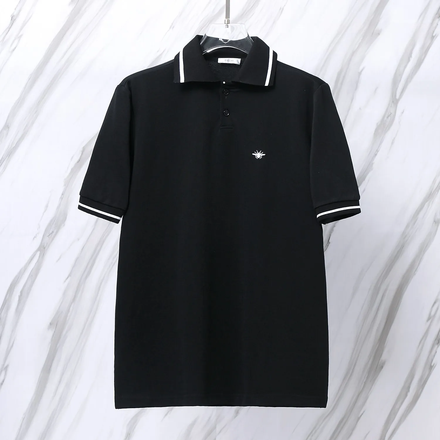 🅿️190 Item No. D41 (Dior classic little bee embroidered logo POLO shirt) Dior Dior 24ss new little bee letter embroidered logo lapel Polo shirt short-sleeved T-shirt. The counter restores the top replica for men and women. The own factory style is very good, business commuting, classic POLO lapel design, the classic small logo embroidery design on the chest highlights personality, making the entire line smoother, the most classic evergreen small logo design Exquisite embroidered logo design on the chest, pure cotton texture that is skin-friendly and comfortable. Suitable for both business and leisure. The piqué cotton fabric is more breathable and dry than ordinary knitted fabrics. 3D three-dimensional tailoring technology, the upper body is three-dimensional. The embroidery on the chest is full of details, and the embroidery with thousands of needles is three-dimensional and full. It is made of 240 grams of pure cotton piqué cotton fabric and customized buttons. Top quality product. Color: Black Size: S/M/L/XL