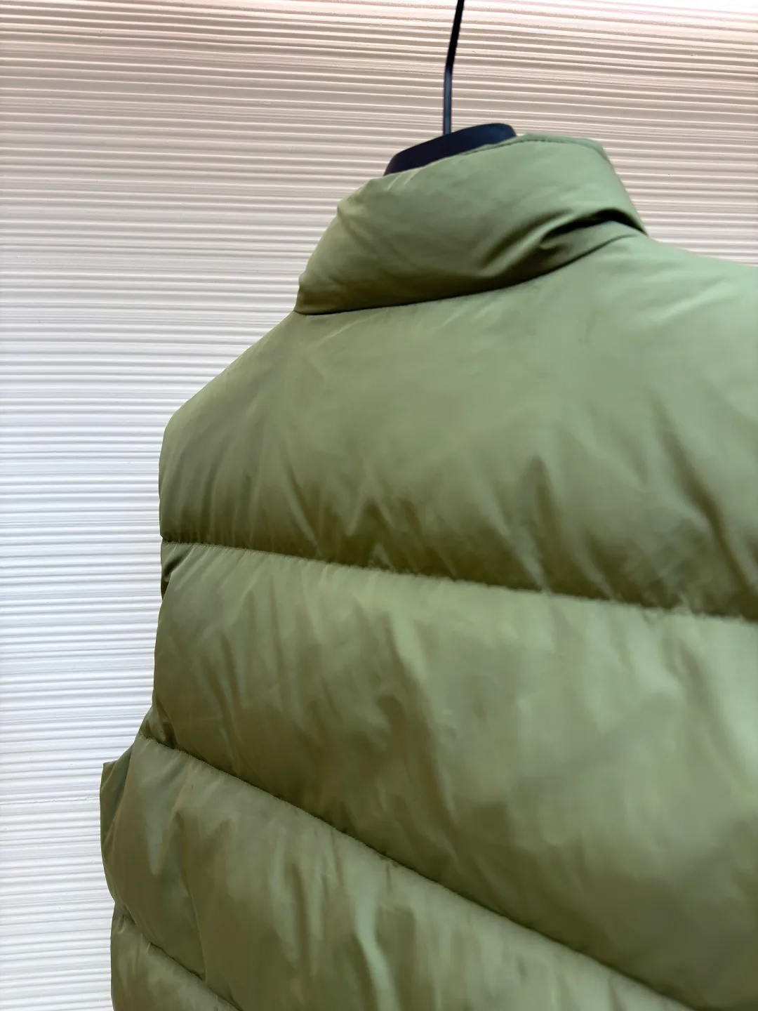 PRADA fabric triangle down vest ●Original version: Purchased and developed by 11909 ●Item number: 1681118-C10 ●Fabric: white duck down fabric ●Technology: patch production ●Version: fitted version ●Weight: about 430 grams ●Size: 46-48-50-52 ●Description: The brand's iconic regenerated nylon fabric is selected, which has the same performance as traditional nylon, with high strength, tear resistance, wear resistance and other characteristics. It is lightweight and waterproof, suitable for various scenarios. Anti-wrinkle, quick-drying and easy to maintain on a daily basis. The felt cloth material is flatly fixed on the stamping machine table. Under the control of the ground controller, the upper mold is driven to move downward at extremely high speed and pressure. The sharp edge under pressure cuts off the felt cloth fibers instantly and cleanly like a paper knife. The whole process is completed within milliseconds. Through precise calculation, the triangle shape with no burrs and brushed edges is formed. It uses 90 white duck down with a weight of 160g to ensure excellent thermal insulation performance. After strict screening and processing, the velvet is not easy to drill, ensuring durability. The overall wiring is straight and delicate, the fabric is comfortable and soft, and the color is consistent without color difference. It can be matched with the same style to create a fashionable look and control various occasions. Customized accessories, complete with three standards, same style for men and women!
