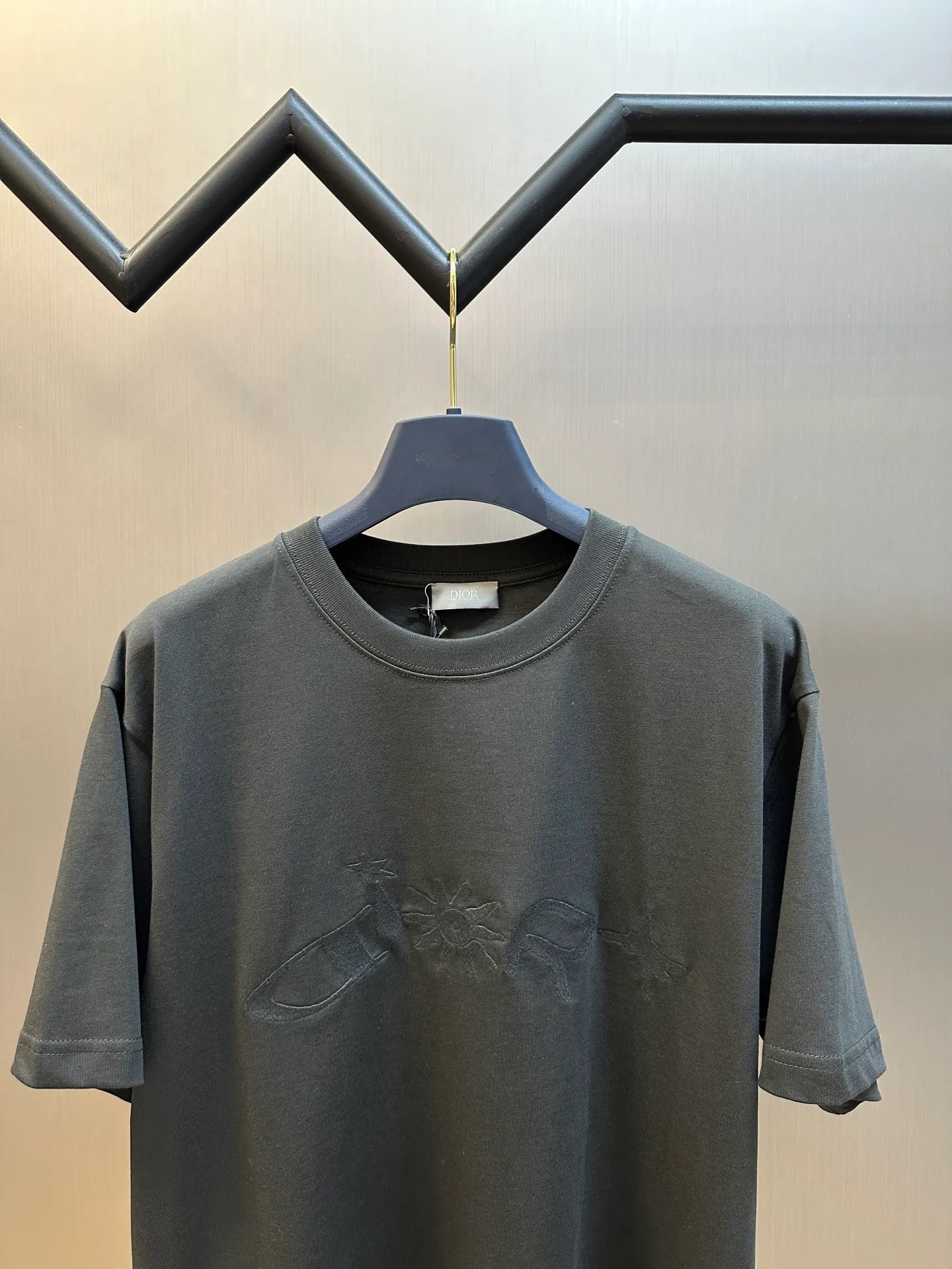 🅿️260 Dior co-branded embroidered round neck short-sleeved cotton jersey fabric, made of 15S fine cotton plain weave, 230g; paired with threaded 32S double yarn rack, 300g. 15S is a relatively thick yarn used to make thicker and more durable fabrics. The fabric made of pure cotton natural fiber has the characteristics of good hygroscopicity, strong breathability, softness and comfort. Cotton fabrics are generally suitable for summer wear and can help keep your body dry and comfortable. The yarn passes alternately in the horizontal and vertical directions to form a simple cross structure; it has good elasticity and wear resistance.  It is processed by needle embroidery process, and the main body adopts precision needle embroidery process; the embroidery is very fine and dense, the pattern is clear and the lines and three-dimensional sense are strong. The linen material embroidery thread is combined with encrypted processing, and the embroidery body has a subtle matte visual texture; the embroidery effect is three-dimensional and full. The flat embroidery has a unique needle-to-needle design, and the embroidery is very fine and dense. The overall stitching is fine, with consistent fineness and texture, adding a sense of layering to the simple design.  The standard round neck and short-sleeved version has a rounded arc neckline, which is suitable for various face shapes and body shapes; the sleeve length is moderate and ends just above the elbow, showing a smart and neat image. The slim fit can show off the wearer's body curves without sacrificing comfort. The collar, cuffs, hem and other parts are all sewn with fine double-needle stitching.  size：xs s m l