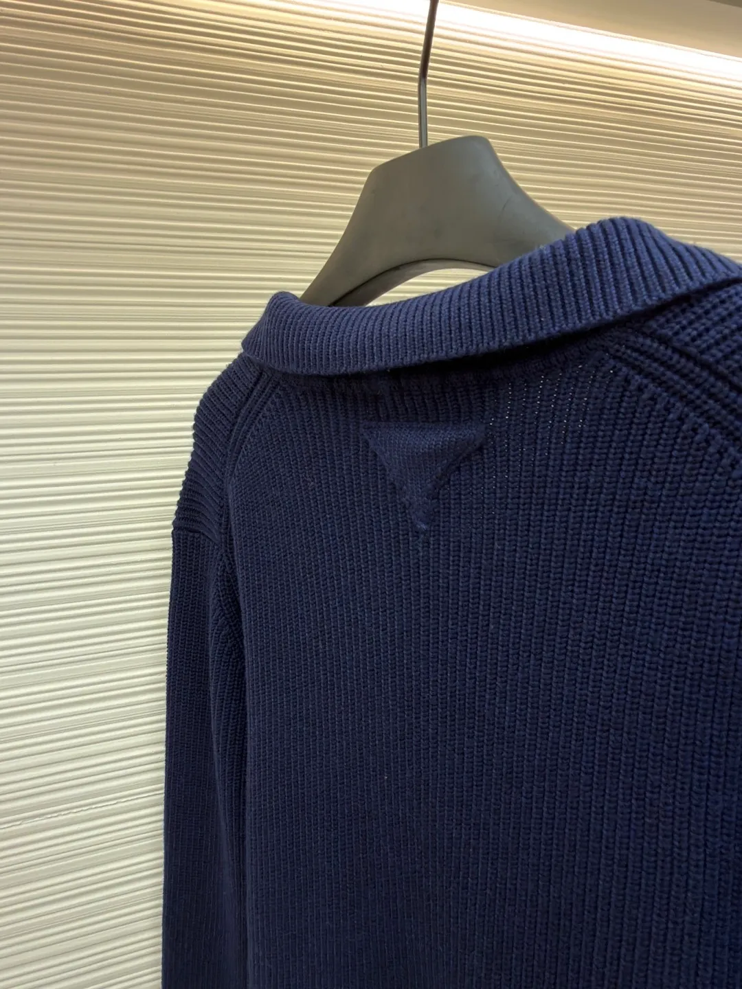 PRADA Triangle logo seagull collar knitted sweater ●Item number: 1681465-A75 ●Material: 100% cotton ●Technology: knitting ●Color: navy ●Version: fitted version ●Weight: about 840 grams ●Size: S-M-L-XL ●Description: This sweater uses Polo collar knitting technology, with a crisp and stylish neckline, blending casualness and sophistication. Using thick needle texture weaving technology, the body texture is clear and rich in texture, creating a retro and simple style. In terms of details, the precise splicing process of the collar and placket ensures neat and natural stitching, ensuring the neatness of the silhouette; the rib knitting process of the cuffs and hem has moderate elasticity, which not only fits the body shape but also enhances the comfort of wearing. Made of high-quality knitted fabric and finely woven, it is skin-friendly, breathable and has a crisp silhouette. From the design of the neckline to the presentation of texture, every craftsmanship reflects the pursuit of classic styles and delicate workmanship. It is a knitted item that combines daily practicality with style. The overall wiring is straight and delicate, the fabric is comfortable and soft, and the color is consistent without color difference. It can be matched with the same style to create a fashionable look and control various occasions. Customized accessories, complete with three standards, same style for men and women!