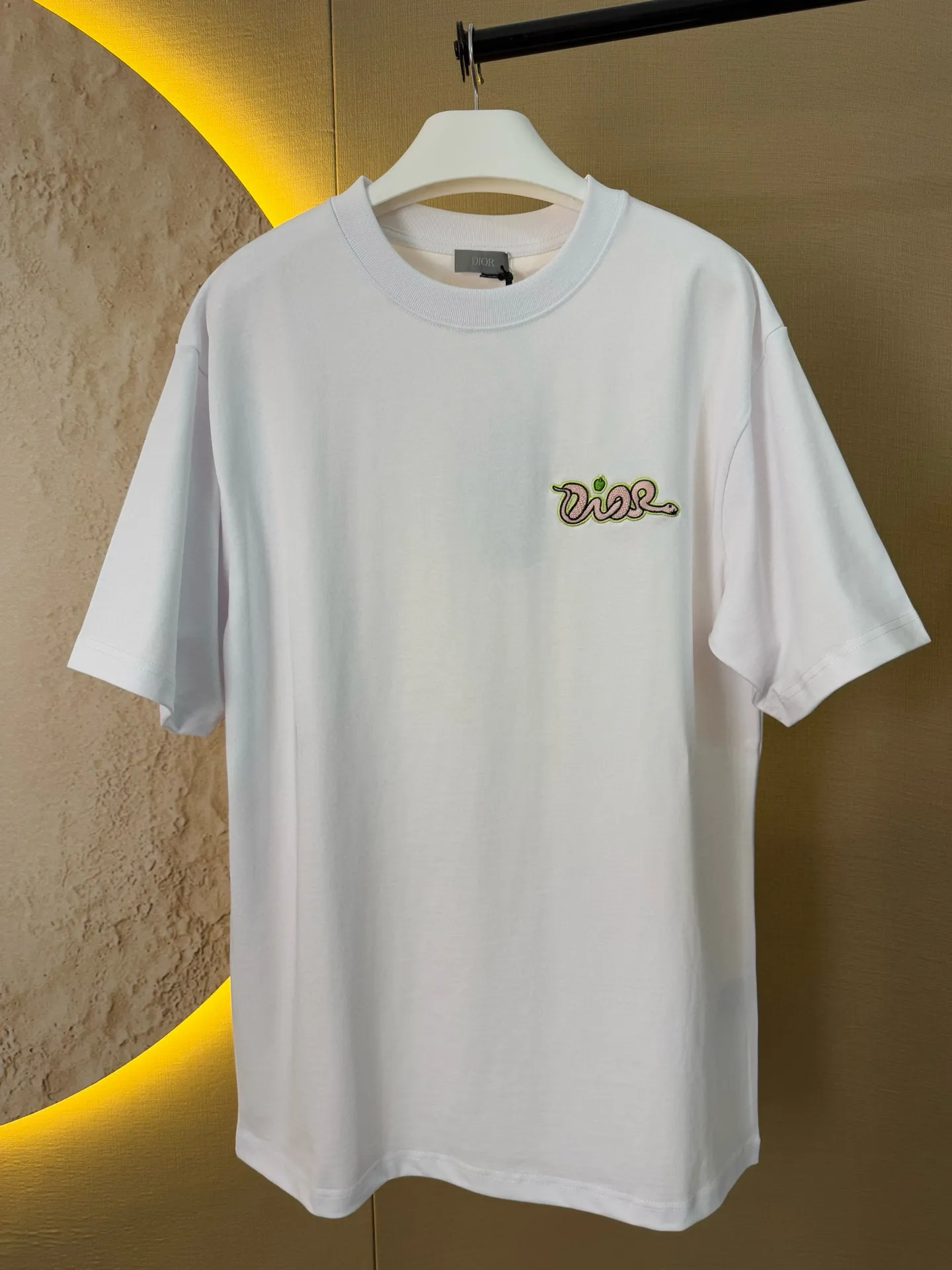🅿️156 Dior Year of the Snake Limited Edition Apple Snake Embroidered Badge Short Sleeve Made of pure cotton 12S fine cotton plain fabric, 310g. The embroidery pattern is based on tatami embroidery technology. The embroidery uses a special single-needle arrangement. The stitches are tight and flat, forming a texture similar to the tatami grid, making the embroidery pattern have a strong three-dimensional and layered feel. Embroidered with silk threads of multiple colors, the colors are bright and contrasting, showing rich patterns and details. The outline is stroked by needle embroidery, the embroidery pattern is matched with the brand logo design, and the brand letter logo is single-needle flat embroidered. Made from a variety of needlework; the outline of the pattern is embroidered with a single straight line and straight silk thread. The outline edges and letter embroidery are stitched together to create clear and rich three-dimensional layers. The standard round neck and short-sleeved version has a rounded arc neckline, which is suitable for various face shapes and body shapes; the sleeve length is moderate and ends just above the elbow, showing a smart and neat image. The slim fit can show off the wearer's body curves without sacrificing comfort. The collar, cuffs, hem and other parts are all sewn with fine double-needle stitching. Size: S-XL