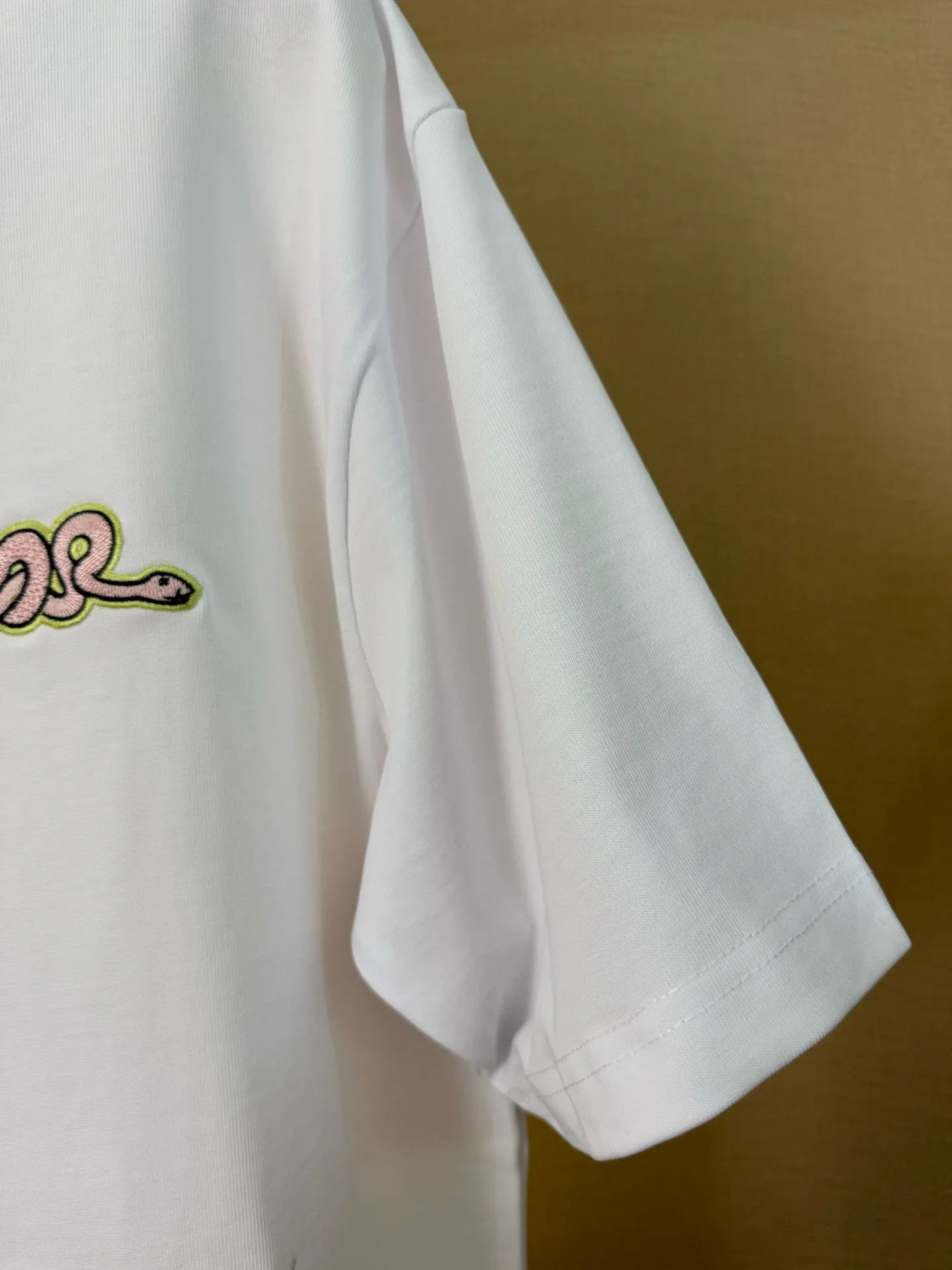 🅿️156 Dior Year of the Snake Limited Edition Apple Snake Embroidered Badge Short Sleeve Made of pure cotton 12S fine cotton plain fabric, 310g. The embroidery pattern is based on tatami embroidery technology. The embroidery uses a special single-needle arrangement. The stitches are tight and flat, forming a texture similar to the tatami grid, making the embroidery pattern have a strong three-dimensional and layered feel. Embroidered with silk threads of multiple colors, the colors are bright and contrasting, showing rich patterns and details. The outline is stroked by needle embroidery, the embroidery pattern is matched with the brand logo design, and the brand letter logo is single-needle flat embroidered. Made from a variety of needlework; the outline of the pattern is embroidered with a single straight line and straight silk thread. The outline edges and letter embroidery are stitched together to create clear and rich three-dimensional layers. The standard round neck and short-sleeved version has a rounded arc neckline, which is suitable for various face shapes and body shapes; the sleeve length is moderate and ends just above the elbow, showing a smart and neat image. The slim fit can show off the wearer's body curves without sacrificing comfort. The collar, cuffs, hem and other parts are all sewn with fine double-needle stitching. Size: S-XL