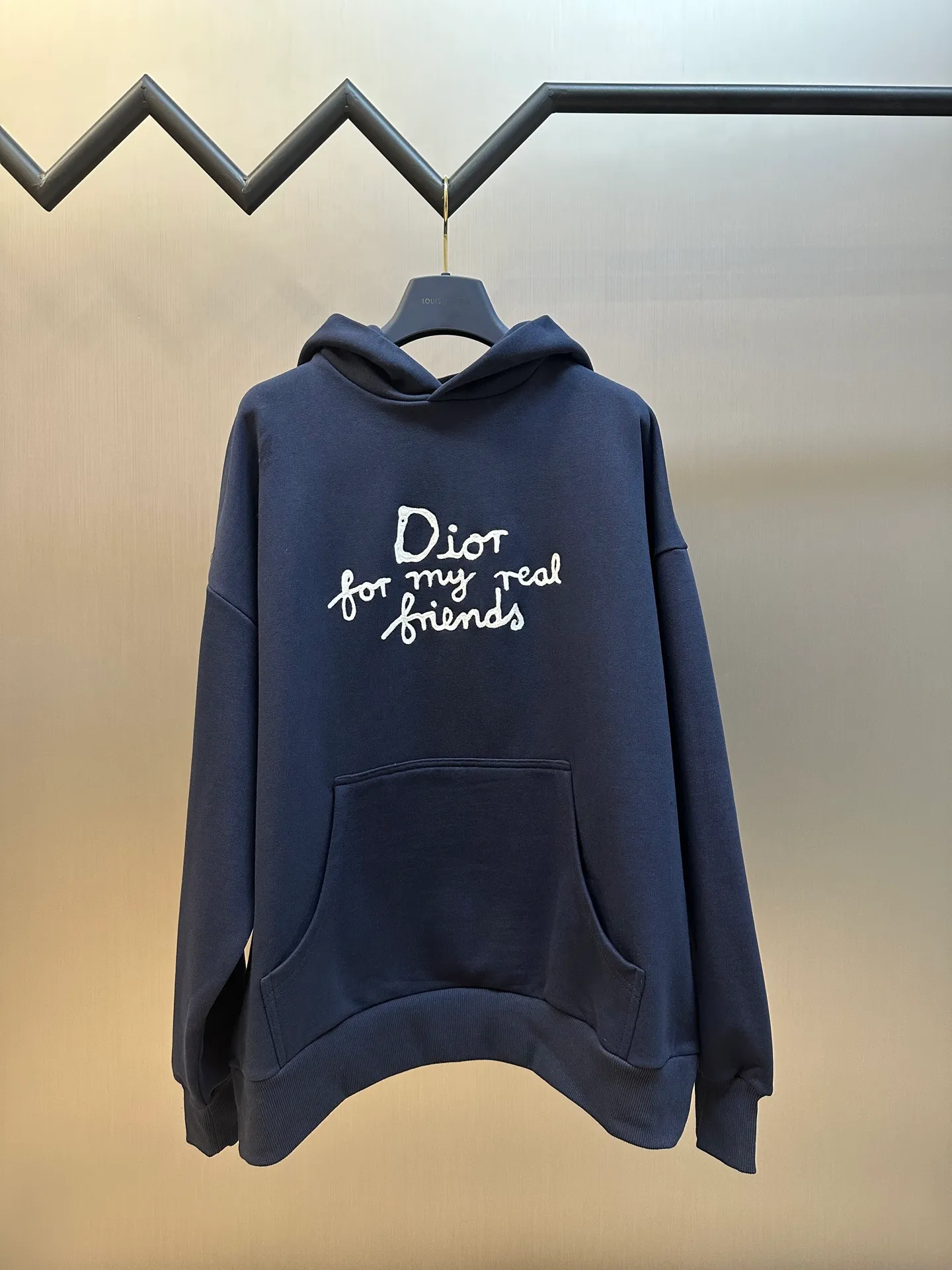 🅿️500 Dior Friends letter embroidered hooded sweatshirt. Cotton fleece fish scale bottom fabric. The surface of the 32-count double-yarn woven fabric is fine and tight, and it feels soft and comfortable. The weight of 50g and the bottom design of 10-count yarn make the fabric have good warmth retention and durability. Thanks to the relatively fine yarns used, this sweatshirt fabric is soft to the touch and comfortable to wear. The design of the fish scale base also increases the skin-friendliness of the fabric, making the wearing experience better. This fabric maintains softness while also possessing good wear-resistance and wrinkle-resistance.  The joint series logo is chain embroidery. Chain embroidery is named because the visual effect of the embroidery is like a chain. The shape is like the links on the chain. It is commonly known as chain embroidery and also called chain eye embroidery. Follow the chain stitch stitch method and embroider from right to left. Maintain the tension of the embroidery thread and the uniformity of the stitches to ensure the three-dimensionality and exquisiteness of the embroidery. It combines the stitching method of chain embroidery with the material of fine wool to create embroidery with chain-like texture and three-dimensional effect.  The hooded drop-shoulder is a loose fit, because it is quite loosely cut, and the shoulder line is large. The drop-shoulder design has no limit on shoulder width. The hem and cuffs are spliced ​​with ribs, which can provide wind protection; the hooded sweatshirt maintains a certain degree of looseness while maintaining a slim fit. The length of the sweatshirt is moderate, which can show the curves of the figure and present an elegant and fashionable feeling.  size：xs s m l