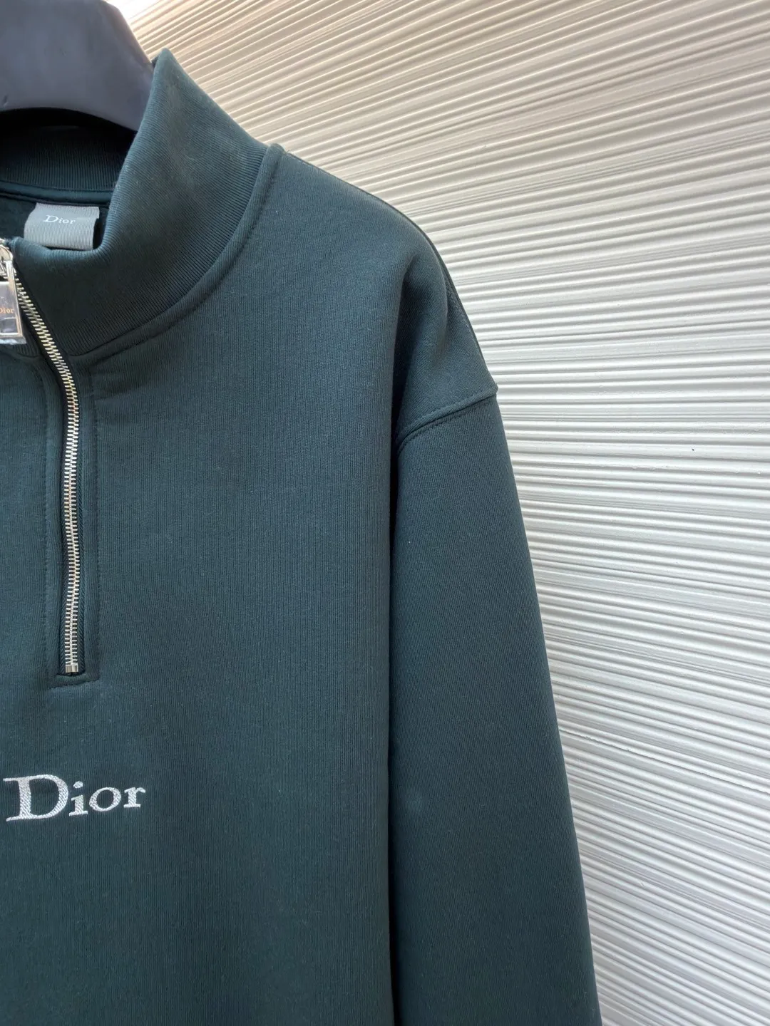 Dior half-zip logo sweatshirt ●Original version: 14,000 purchased and developed ●Item number: 1682498-A95 ●Material: pure cotton plush fabric ●Technology: twill logo embroidery production ●Color: green ●Version: fitted version ●Weight: about 685 grams ●Size: XS-S-M-L ●Description: The fabric is a heavyweight high-end sweatshirt fabric. The 26-count double yarn forms the smooth and delicate outer surface of the fabric, while the 10-count plush yarn base is precision brushed to form a layer of rich, dense skin-friendly fluff, providing excellent softness and warmth. Its extremely high weight and elasticity brought by spandex ensure the ultimate thickness, stiffness and strong elastic recovery of the collar, cuffs and hem, which is the key to creating a neat silhouette and ensuring durability. Made of twill flat stitch embroidery. This is an embroidery technique that uses parallel stitches at specific angles to fill in, creating a flat, smooth and full embroidery surface with fine diagonal texture. The brand logo is presented in a delicate, strong and textured way, and the precision of the embroidery creates a high-end contrast with the casual feel of the sweatshirt fabric. The overall wiring is straight and delicate, the fabric is comfortable and soft, and the color is consistent without color difference. It can be matched with the same style to create a fashionable look and control various occasions. Customized accessories, complete with three standards, same style for men and women!