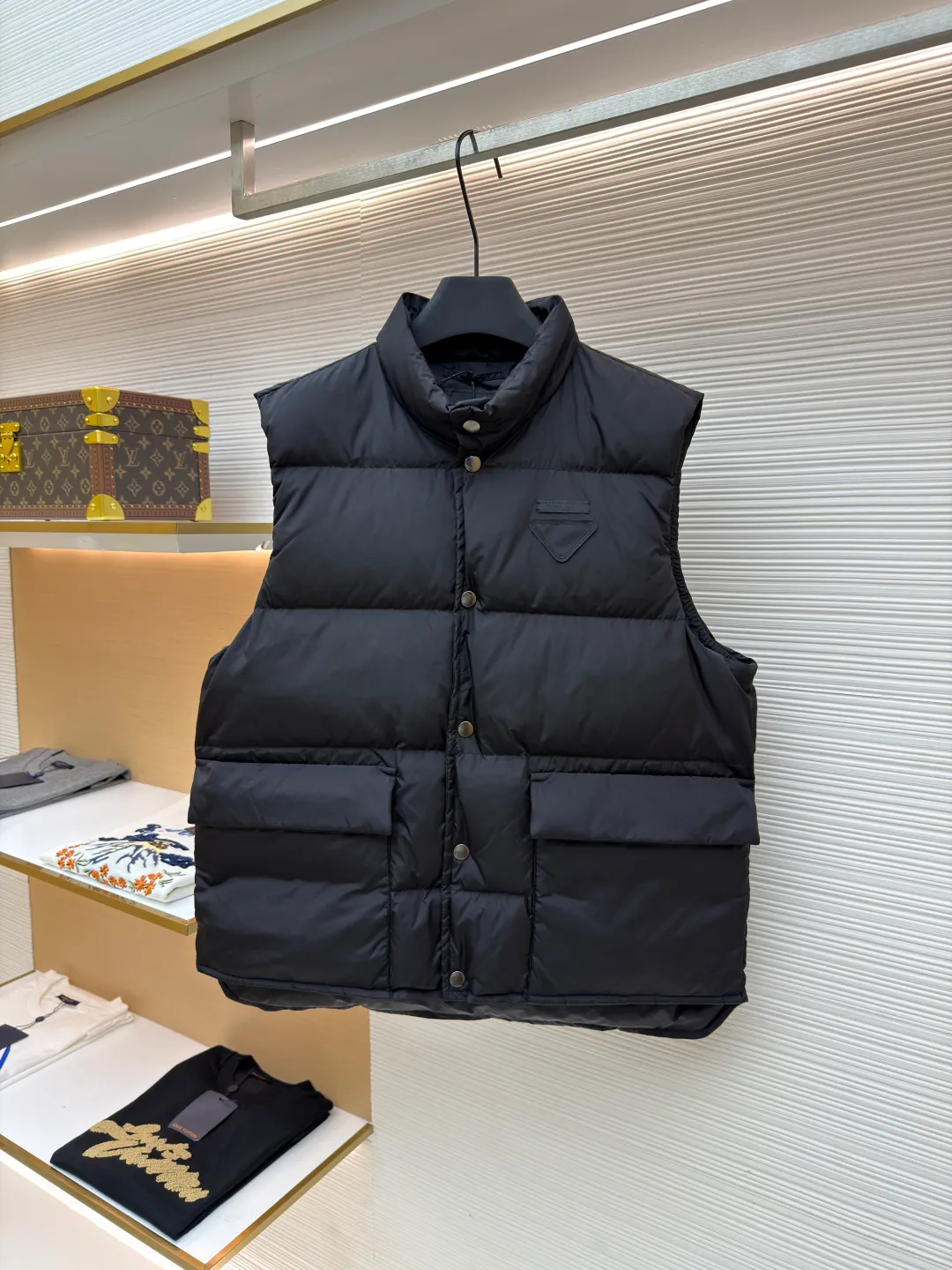 PRADA fabric triangle down vest ●Original version: purchased and developed by 12092 ●Item number: 1681119-C10 ●Fabric: white duck down fabric ●Technology: patch production ●Version: fitted version ●Weight: about 430 grams ●Size: 46-48-50-52 ●Description: The brand's iconic regenerated nylon fabric is selected, which has the same performance as traditional nylon, with high strength, tear resistance, wear resistance and other characteristics. It is lightweight and waterproof, suitable for various scenarios. Anti-wrinkle, quick-drying and easy to maintain on a daily basis. The felt cloth material is flatly fixed on the stamping machine table. Under the control of the ground controller, the upper mold is driven to move downward at extremely high speed and pressure. The sharp edge under pressure cuts off the felt cloth fibers instantly and cleanly like a paper knife. The whole process is completed within milliseconds. Through precise calculation, the triangle shape with no burrs and brushed edges is formed. It uses 90 white duck down with a weight of 160g to ensure excellent thermal insulation performance. After strict screening and processing, the velvet is not easy to drill, ensuring durability. The overall wiring is straight and delicate, the fabric is comfortable and soft, and the color is consistent without color difference. It can be matched with the same style to create a fashionable look and control various occasions. Customized accessories, complete with three standards, same style for men and women!