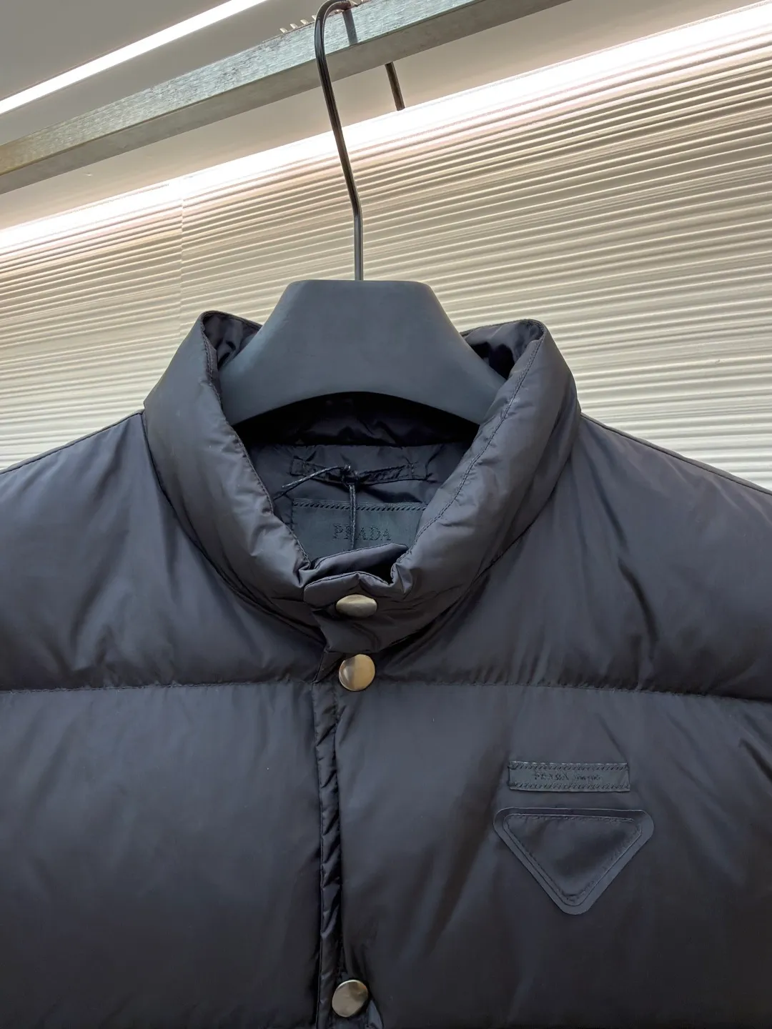 PRADA fabric triangle down vest ●Original version: purchased and developed by 12092 ●Item number: 1681119-C10 ●Fabric: white duck down fabric ●Technology: patch production ●Version: fitted version ●Weight: about 430 grams ●Size: 46-48-50-52 ●Description: The brand's iconic regenerated nylon fabric is selected, which has the same performance as traditional nylon, with high strength, tear resistance, wear resistance and other characteristics. It is lightweight and waterproof, suitable for various scenarios. Anti-wrinkle, quick-drying and easy to maintain on a daily basis. The felt cloth material is flatly fixed on the stamping machine table. Under the control of the ground controller, the upper mold is driven to move downward at extremely high speed and pressure. The sharp edge under pressure cuts off the felt cloth fibers instantly and cleanly like a paper knife. The whole process is completed within milliseconds. Through precise calculation, the triangle shape with no burrs and brushed edges is formed. It uses 90 white duck down with a weight of 160g to ensure excellent thermal insulation performance. After strict screening and processing, the velvet is not easy to drill, ensuring durability. The overall wiring is straight and delicate, the fabric is comfortable and soft, and the color is consistent without color difference. It can be matched with the same style to create a fashionable look and control various occasions. Customized accessories, complete with three standards, same style for men and women!