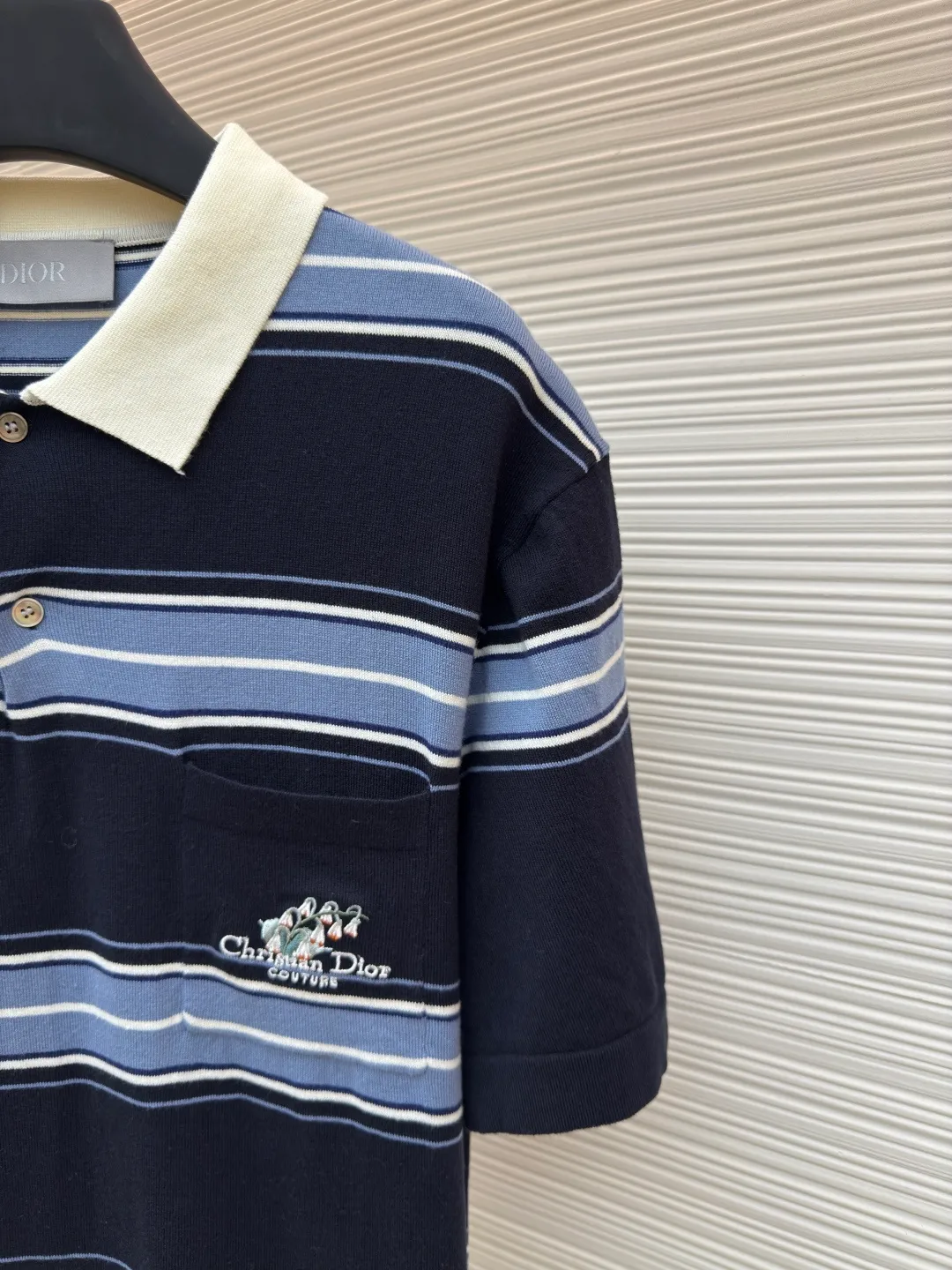 Dior lily of the valley embroidered lapel polo short sleeves ●Authentic product: Purchased and developed by 15150 ●Item number: 1680372-A80 ●Fabric: blue cotton blended woolen fabric ●Technology: embroidery production ●Version: fitted version ●Weight: about 265 grams ●Size: XS-S-M-L ●Description: Blue cotton blended wool jacquard, blue striped cotton blended wool fabric, which combines classic stripe elements with the exquisite craftsmanship of luxury brands. Woven from cotton blended wool, the material is breathable and drapey, and a small amount of synthetic fibers enhance wrinkle resistance. The striped texture design may be achieved through jacquard, welt or contrasting yarn; the surface is fine and smooth, with a slight bump in the striped part. The lily-of-the-valley style embroidery embellishments on the pockets adopt the needle embroidery process, which is a highly artistic and skillful hand-embroidery method; the needle method is used to embroider threads on the fabric to form various exquisite patterns and textures. The stitching has a strong sense of line and three-dimensionality, is lively and has good coverage. By adjusting the shape and size of the embroidery frame, the needle density and gradient density can be adjusted. The simple use of density can produce artistic effects of varying shades and sparses. The overall color is consistent with no color difference. It can be matched with the same style to create a fashionable look, and can be used in various occasions. Customized accessories, complete with three standards, the same style for men and women!