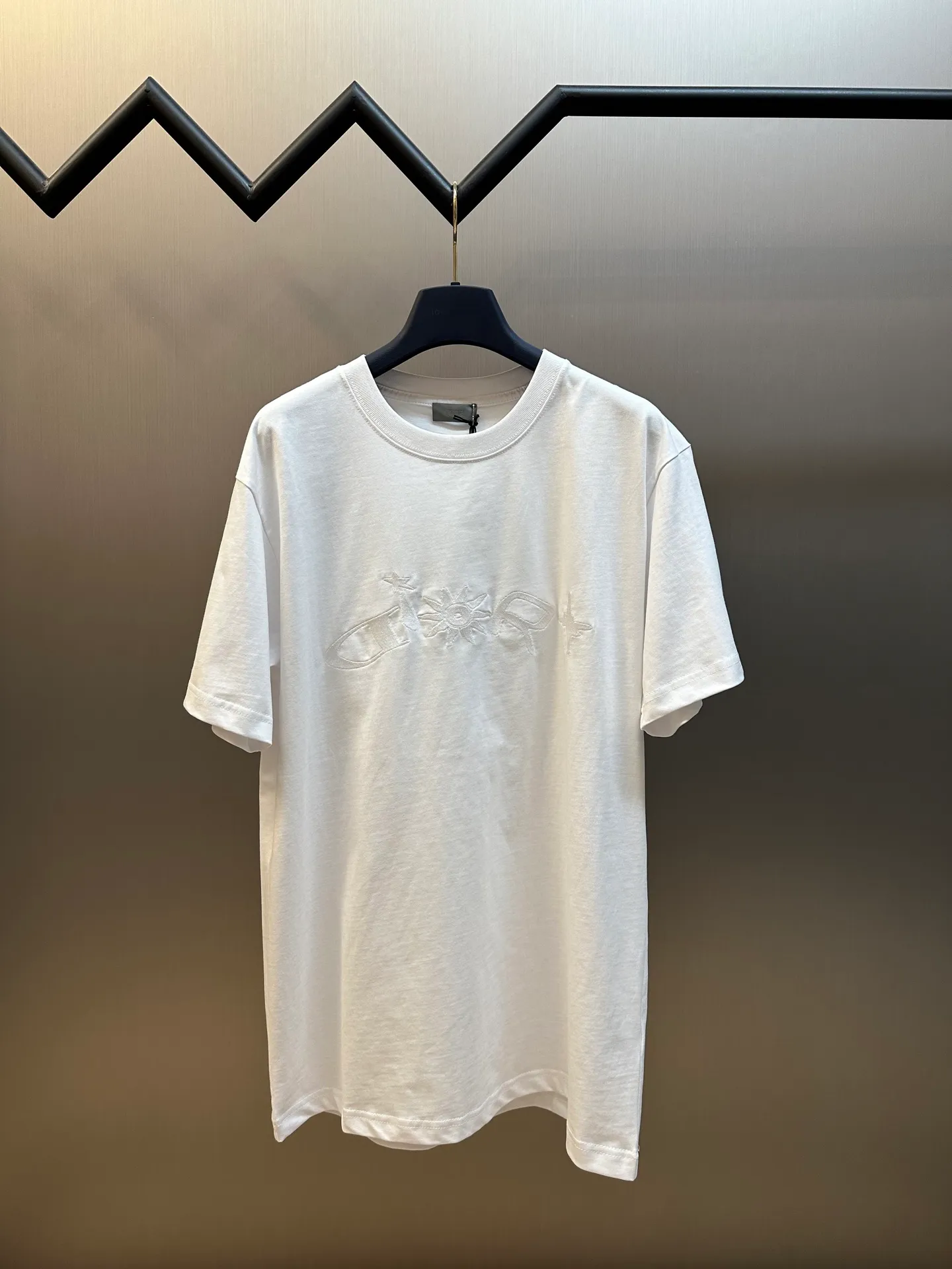 🅿️260 Dior co-branded embroidered round neck short-sleeved cotton jersey fabric, made of 15S fine cotton plain weave, 230g; paired with threaded 32S double yarn rack, 300g. 15S is a relatively thick yarn used to make thicker and more durable fabrics. The fabric made of pure cotton natural fiber has the characteristics of good hygroscopicity, strong breathability, softness and comfort. Cotton fabrics are generally suitable for summer wear and can help keep your body dry and comfortable. The yarn passes alternately in the horizontal and vertical directions to form a simple cross structure; it has good elasticity and wear resistance.  It is processed by needle embroidery process, and the main body adopts precision needle embroidery process; the embroidery is very fine and dense, the pattern is clear and the lines and three-dimensional sense are strong. The linen material embroidery thread is combined with encrypted processing, and the embroidery body has a subtle matte visual texture; the embroidery effect is three-dimensional and full. The flat embroidery has a unique needle-to-needle design, and the embroidery is very fine and dense. The overall stitching is fine, with consistent fineness and texture, adding a sense of layering to the simple design.  The standard round neck and short-sleeved version has a rounded arc neckline, which is suitable for various face shapes and body shapes; the sleeve length is moderate and ends just above the elbow, showing a smart and neat image. The slim fit can show off the wearer's body curves without sacrificing comfort. The collar, cuffs, hem and other parts are all sewn with fine double-needle stitching.  size：xs s m l