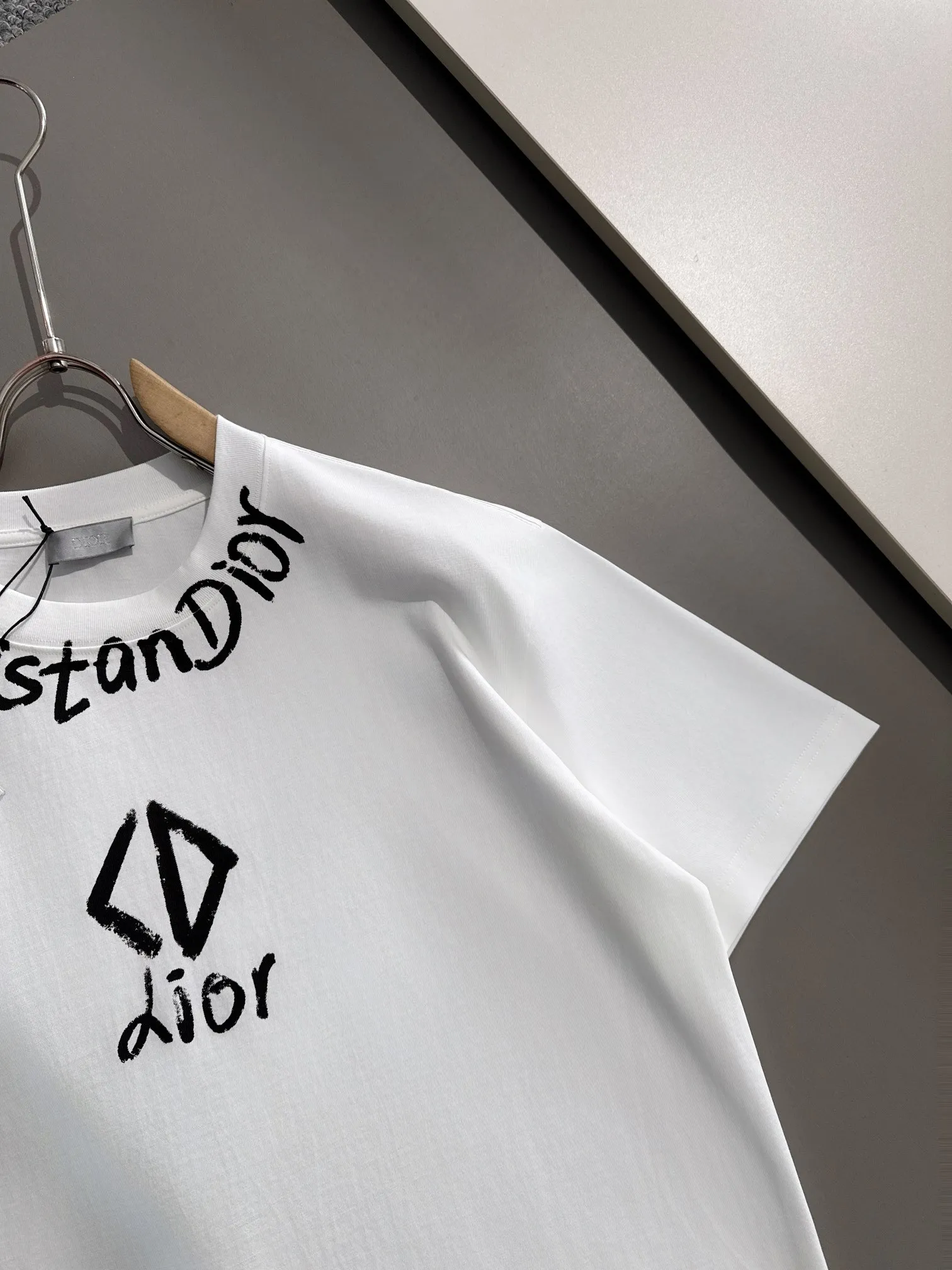 🅿️170 (arrives the next day) Dior 2025 new style front and back graffiti letter logo, same style for men and women, short-sleeved T-shirt ·Customized 260g 100% double yarn pure cotton fabric ·Dyeing 32 counts double-strand thread ·Collar label, hangtag, main mark and three labels complete Color: White Size: XS S M L