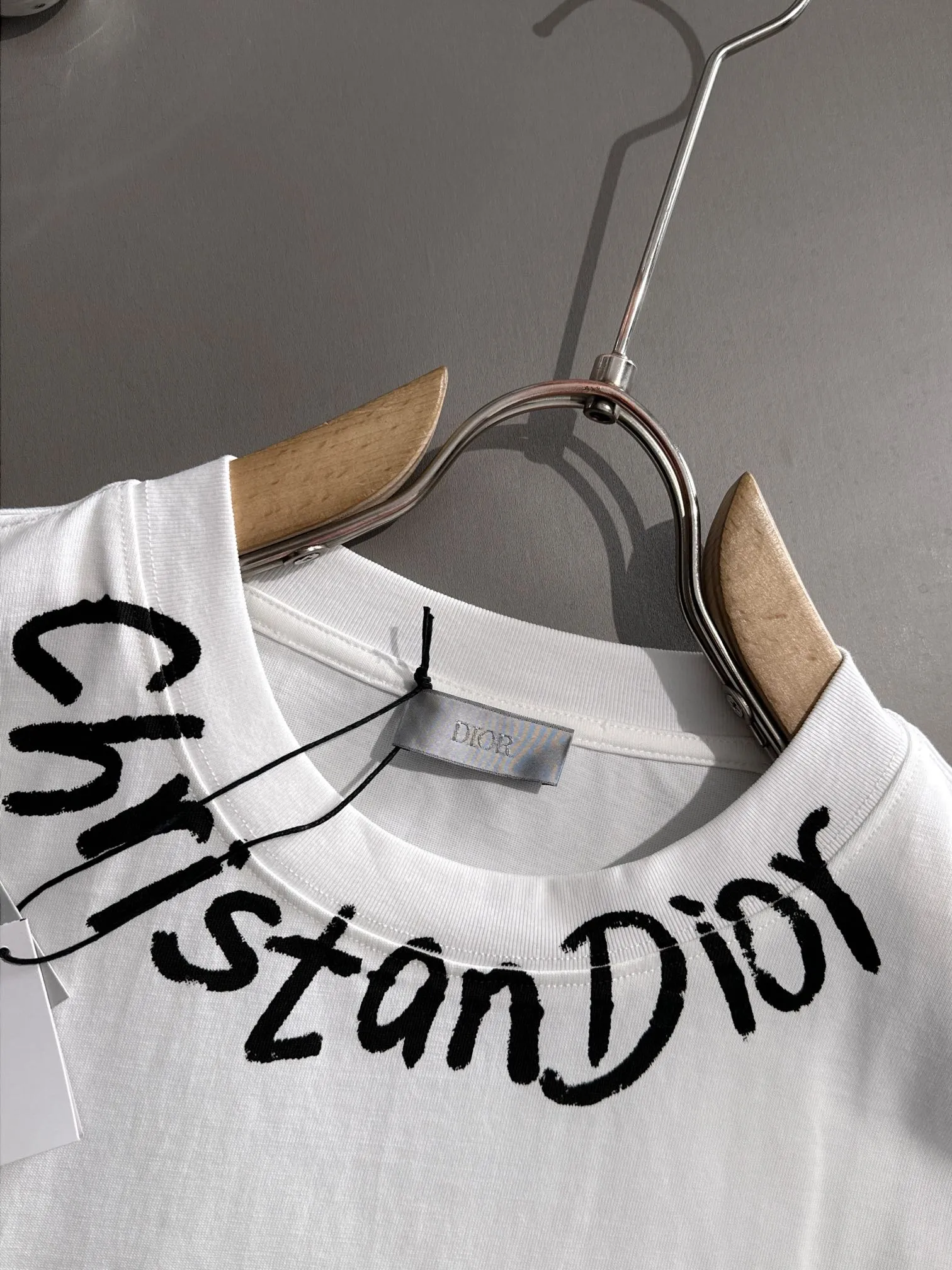 🅿️170 (arrives the next day) Dior 2025 new style front and back graffiti letter logo, same style for men and women, short-sleeved T-shirt ·Customized 260g 100% double yarn pure cotton fabric ·Dyeing 32 counts double-strand thread ·Collar label, hangtag, main mark and three labels complete Color: White Size: XS S M L