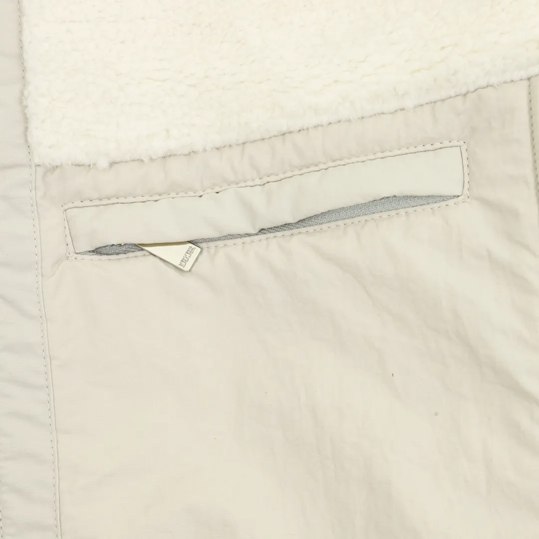 🅿️570 DIOR/Dior Teddy Velvet Logo Zipper Jacket The polyester filament is passed through a circular knitting machine, and the warp and weft are woven into each other into a double-sided knitted structure, with flat loops on the front and back. The polar fleece fabric is formed after a series of processes such as dyeing, raising, carding, shearing, and polarization. The suede texture is soft and the fiber characteristics make it almost non-absorbent. It can quickly drain sweat to the outer layer of the fabric and evaporate quickly, maintaining good breathability. The suede surface can lock the air and form a stagnant air layer around the body, effectively preventing heat loss and providing good warmth retention properties. Using quilted cannage pattern, the seamstress precisely adjusts the speed of the machine and stitch density, so that the stitches are smooth and even during the operation. After completion, regular diagonal quilting lines will be formed, which will inadvertently enhance the overall texture when putting it on and taking it off. Tightly fasten the fabric and cushioning material to the frame of the embroidery machine. The embroidery machine uses sparse stitches along the pattern of the cushion layer to outline the filling area of ​​the pattern. Then it runs the pattern of the overlay layer, using dense stitches to perfectly cover the foam cushion layer. After finishing, the edges of the patch will have no burrs and the pattern will be clear. Size：XS-L