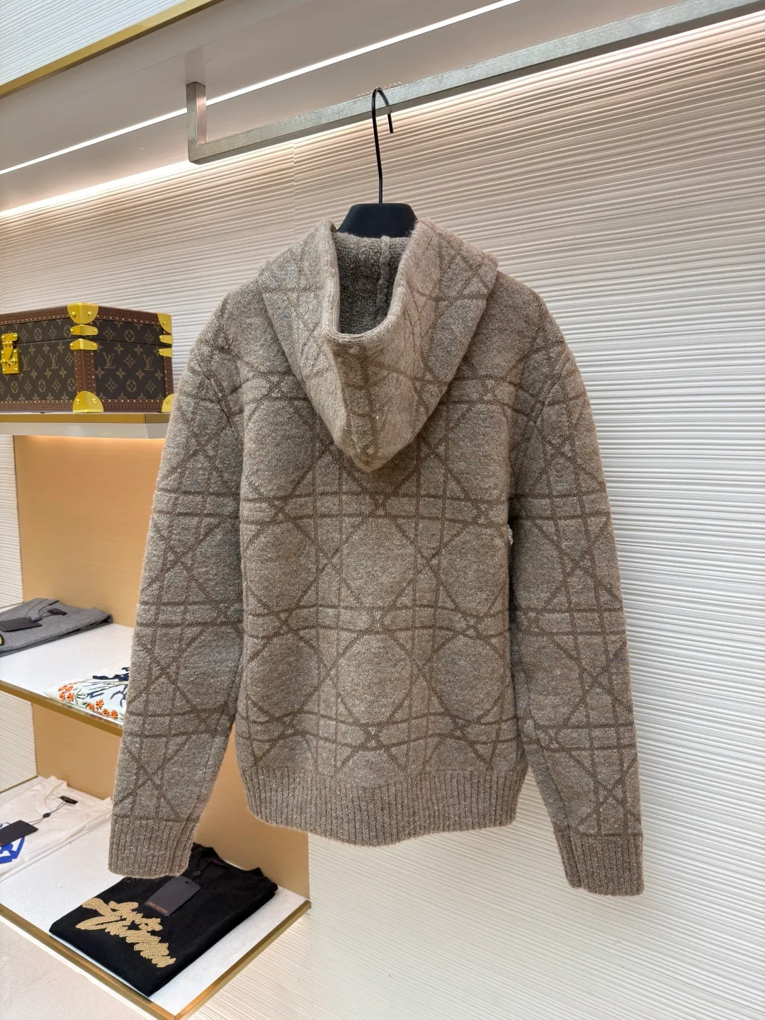 Dior diamond pattern jacquard knitted hoodie ●Original version: purchased and developed in 19726 ●Item number: 1681970-C70 ●Fabric: wool blended fabric ●Technology: jacquard knitting ●Color: camel ●Version: fitted version ●Weight: about 1315 grams ●Size: S-M-L-XL ●Description: This is LV The 2025 autumn and winter series of plush hooded sweaters are made of 100% Albaka wool blend, and the yarn contains 30% alpaca. It is woven with a 16-needle coarse weaving process. The surface presents a matte plush texture and is twice as warm as ordinary wool. The main body of the garment is made of rhombus plaid jacquard, with a three-dimensional texture formed by alternating front and back stitching techniques without additional seams. The hood is made of one-piece knitting, with an invisible shaping lining built into the brim, making it more comfortable to wear. The drawstring is made of core-spun rope of the same material, and the rope ends are treated with metal crimping, making it durable and not easy to wear. The finished product is ironed with low-temperature steam to avoid damage to the plush fibers. The cuffs and hem are ribbed for long-lasting elasticity and a good fit. The whole piece is sewn in an Italian workshop, with no exposed threads in the details, continuing the exquisite standards of the brand's high-end knitted items. The overall stitching is straight and delicate, the fabric is comfortable and soft, and the color is consistent with no color difference. It can be matched with the same style to create a fashionable look and control various occasions. Customized accessories, complete with three standards, the same style for men and women!