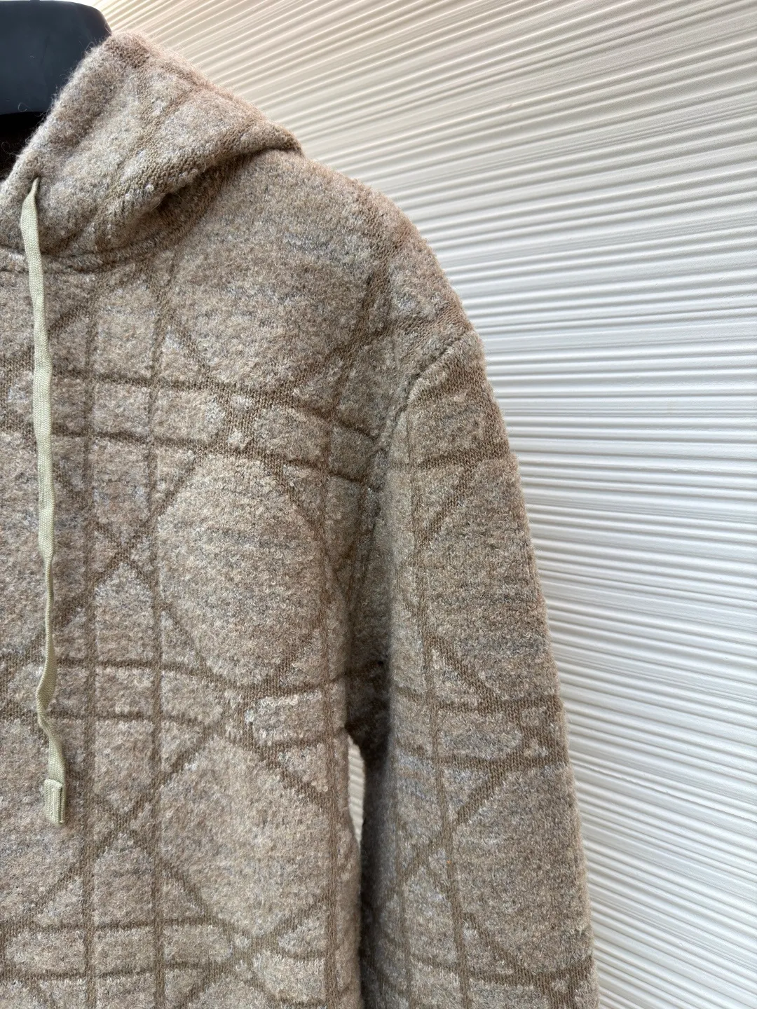 Dior diamond pattern jacquard knitted hoodie ●Original version: purchased and developed in 19726 ●Item number: 1681970-C70 ●Fabric: wool blended fabric ●Technology: jacquard knitting ●Color: camel ●Version: fitted version ●Weight: about 1315 grams ●Size: S-M-L-XL ●Description: This is LV The 2025 autumn and winter series of plush hooded sweaters are made of 100% Albaka wool blend, and the yarn contains 30% alpaca. It is woven with a 16-needle coarse weaving process. The surface presents a matte plush texture and is twice as warm as ordinary wool. The main body of the garment is made of rhombus plaid jacquard, with a three-dimensional texture formed by alternating front and back stitching techniques without additional seams. The hood is made of one-piece knitting, with an invisible shaping lining built into the brim, making it more comfortable to wear. The drawstring is made of core-spun rope of the same material, and the rope ends are treated with metal crimping, making it durable and not easy to wear. The finished product is ironed with low-temperature steam to avoid damage to the plush fibers. The cuffs and hem are ribbed for long-lasting elasticity and a good fit. The whole piece is sewn in an Italian workshop, with no exposed threads in the details, continuing the exquisite standards of the brand's high-end knitted items. The overall stitching is straight and delicate, the fabric is comfortable and soft, and the color is consistent with no color difference. It can be matched with the same style to create a fashionable look and control various occasions. Customized accessories, complete with three standards, the same style for men and women!