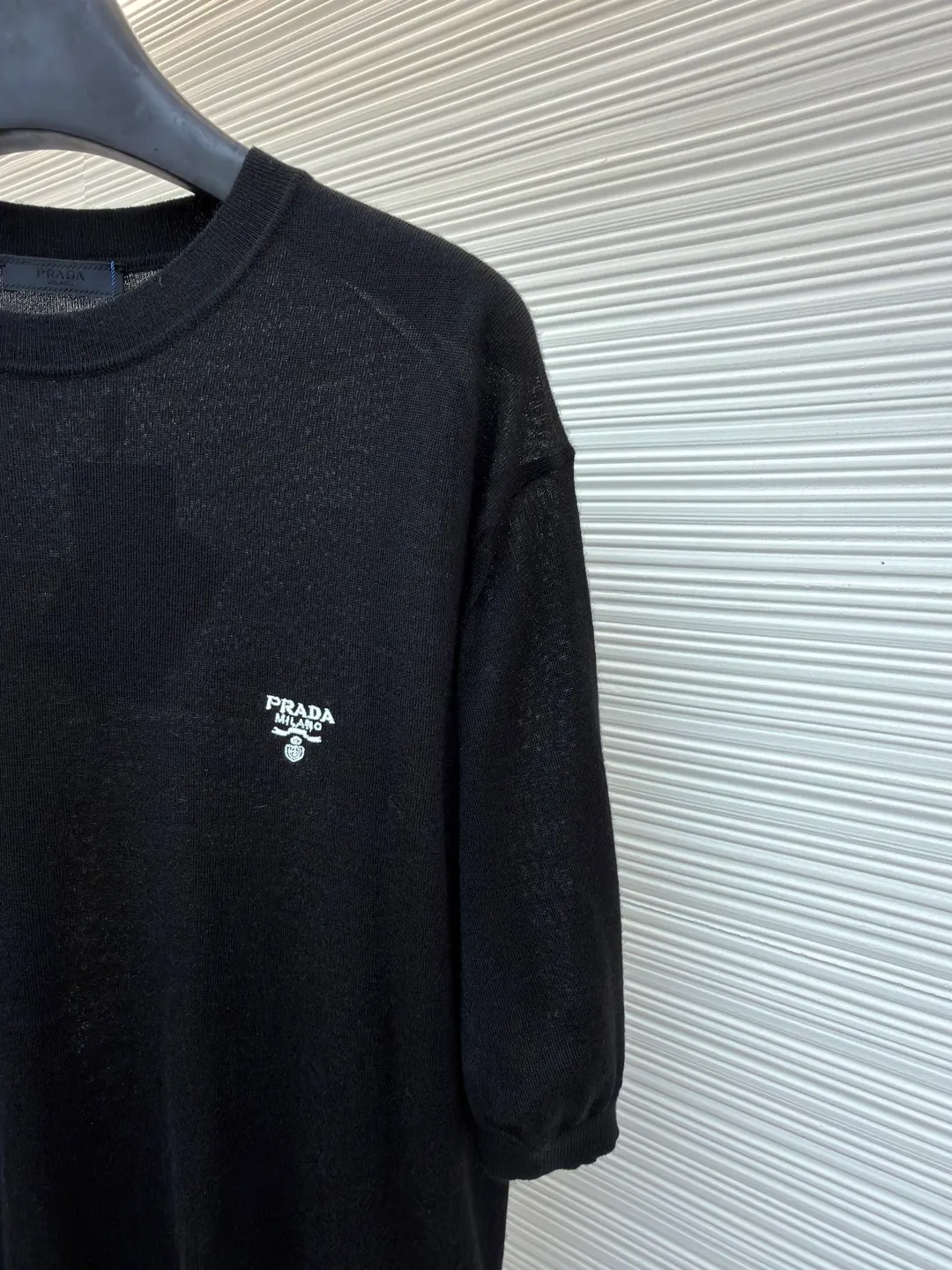 Prada classic LOGO embroidered wool round neck short sleeves ●Original version: purchased and developed by 10479 ●Item number: 1682561-A40 ●Fabric: wool fabric ●Technology: embroidery production ●Color: black ●Version: fitted version ●Weight: about 145 grams ●Size: 46-48-50-52 ●Description: This PRADA classic LOGO embroidered wool round-neck short-sleeve is woven from high-quality pure wool yarn. After the wool washing process, the fabric is delicate and soft, skin-friendly and breathable, and not easy to pill or snag. It has multiple sizes of 46-52 to cover different body shapes. The error of 1-3CM in manual measurement is within the normal range. The body brand LOGO is made using imported embroidery technology. The stitching is dense and regular, and the pattern is clear and three-dimensional. It forms a low-key contrast with the white wool base and highlights the brand recognition. The neckline is a classic round neck design, with double-needle reinforced binding and a custom threaded collar, which is durable and not easy to loosen. The cuffs and hem are ribbed in the same color, with moderate elasticity to fit the body shape. The overall tailoring is a fitted silhouette, with straight and fine stitching at the seams. Customized accessories and three standards are complete. It is recommended to hand wash and maintain. The detailed craftsmanship shows the level of luxury, and is suitable for daily casual, light business and other wear scenarios. The overall wiring is straight and delicate, the fabric is comfortable and soft, and the color is consistent without color difference. It can be matched with the same style to create a fashionable look and control various occasions. Customized accessories, complete with three standards, same style for men and women!