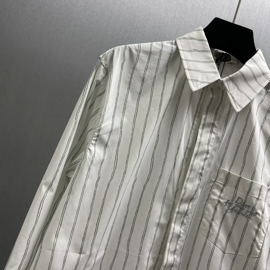 🅿️480 CD Blue and gray vertical pattern simple embroidered shirt Size: S-XL This shirt combines modern style with traditional beauty. Crafted from white cotton poplin, it features a blue and gray striped pattern displaying the Dior For My Real Friends signature from the DIOR AND HYLTON NE collection. A patch pocket on the chest and hidden button closure complete the design. Can be worn with everyday clothing.