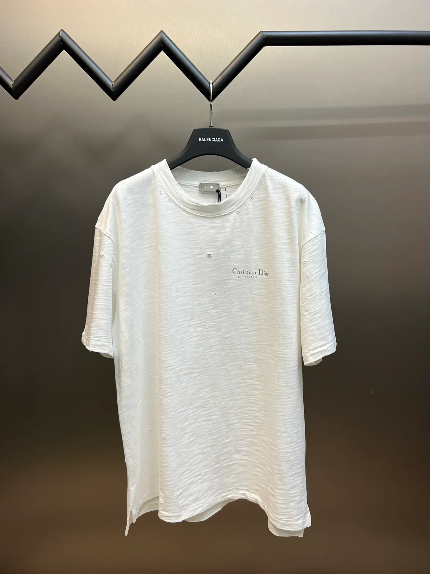 🅿️330 Dior ripped letter print short sleeves The fabric is made of 10s pure cotton slub plain fabric with a weight of 310g. This fabric is used as the collar, and the round collar is manually positioned on a flat machine. The front and back panels are printed with hand-made platen silk screen glue, and the film is engraved with laser dots to create a hollowed-out effect of missing letters. The clothes are designed with bifurcated sides, and the hems of the front and rear panels are cut with a special machine to pick the legs. There are lines on the surface to create a hollow effect. The entire garment is manually positioned and cut with holes, and the garment is fermented and washed to create a nostalgic effect. size：xs s m l