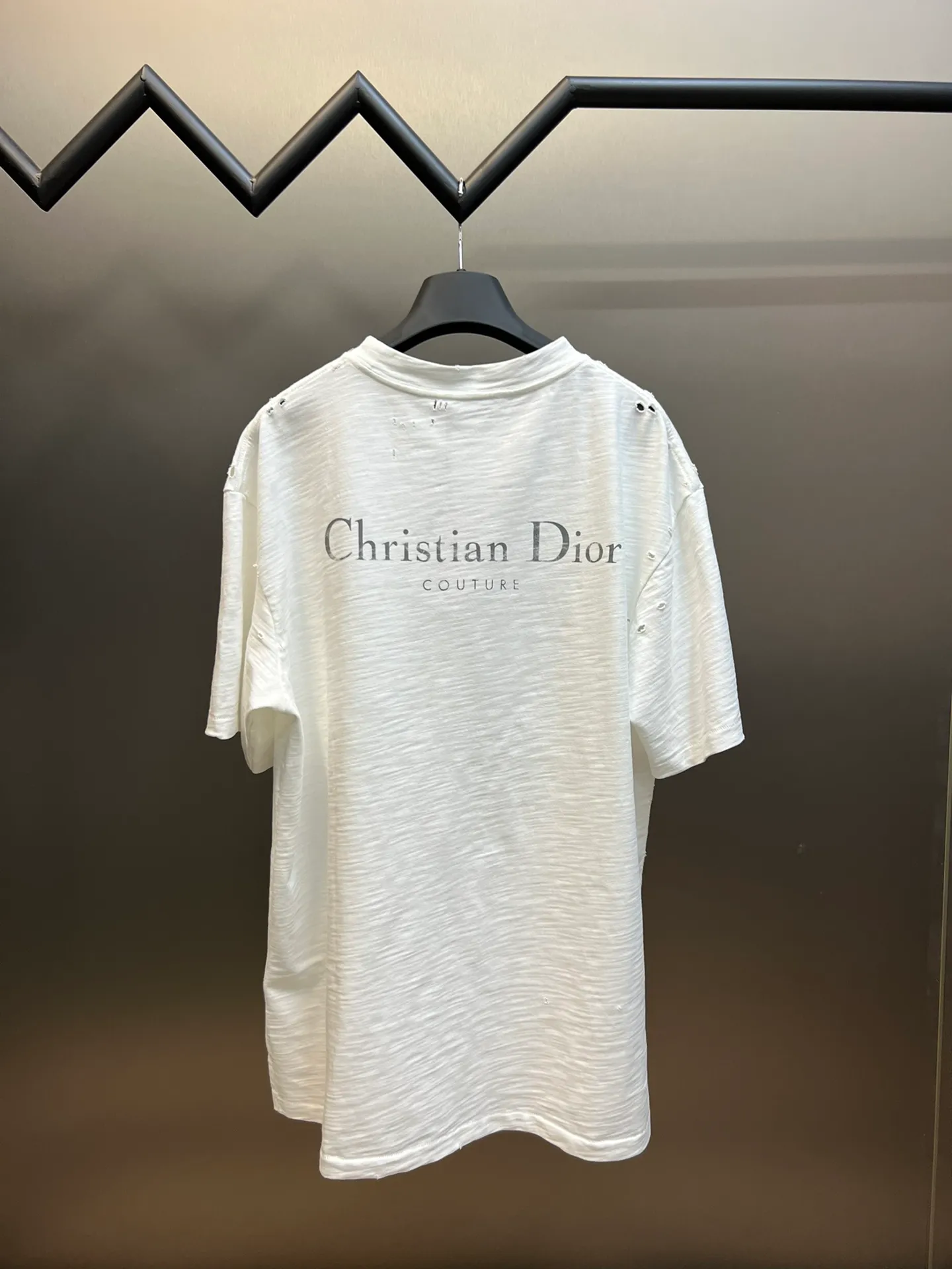 🅿️330 Dior ripped letter print short sleeves The fabric is made of 10s pure cotton slub plain fabric with a weight of 310g. This fabric is used as the collar, and the round collar is manually positioned on a flat machine. The front and back panels are printed with hand-made platen silk screen glue, and the film is engraved with laser dots to create a hollowed-out effect of missing letters. The clothes are designed with bifurcated sides, and the hems of the front and rear panels are cut with a special machine to pick the legs. There are lines on the surface to create a hollow effect. The entire garment is manually positioned and cut with holes, and the garment is fermented and washed to create a nostalgic effect. size：xs s m l