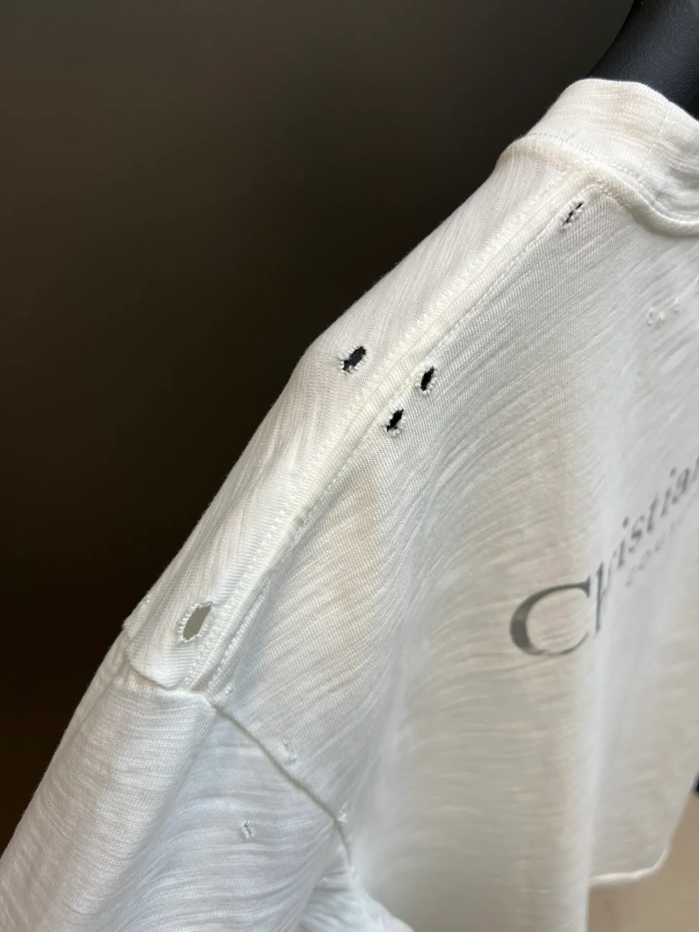 🅿️330 Dior ripped letter print short sleeves The fabric is made of 10s pure cotton slub plain fabric with a weight of 310g. This fabric is used as the collar, and the round collar is manually positioned on a flat machine. The front and back panels are printed with hand-made platen silk screen glue, and the film is engraved with laser dots to create a hollowed-out effect of missing letters. The clothes are designed with bifurcated sides, and the hems of the front and rear panels are cut with a special machine to pick the legs. There are lines on the surface to create a hollow effect. The entire garment is manually positioned and cut with holes, and the garment is fermented and washed to create a nostalgic effect. size：xs s m l