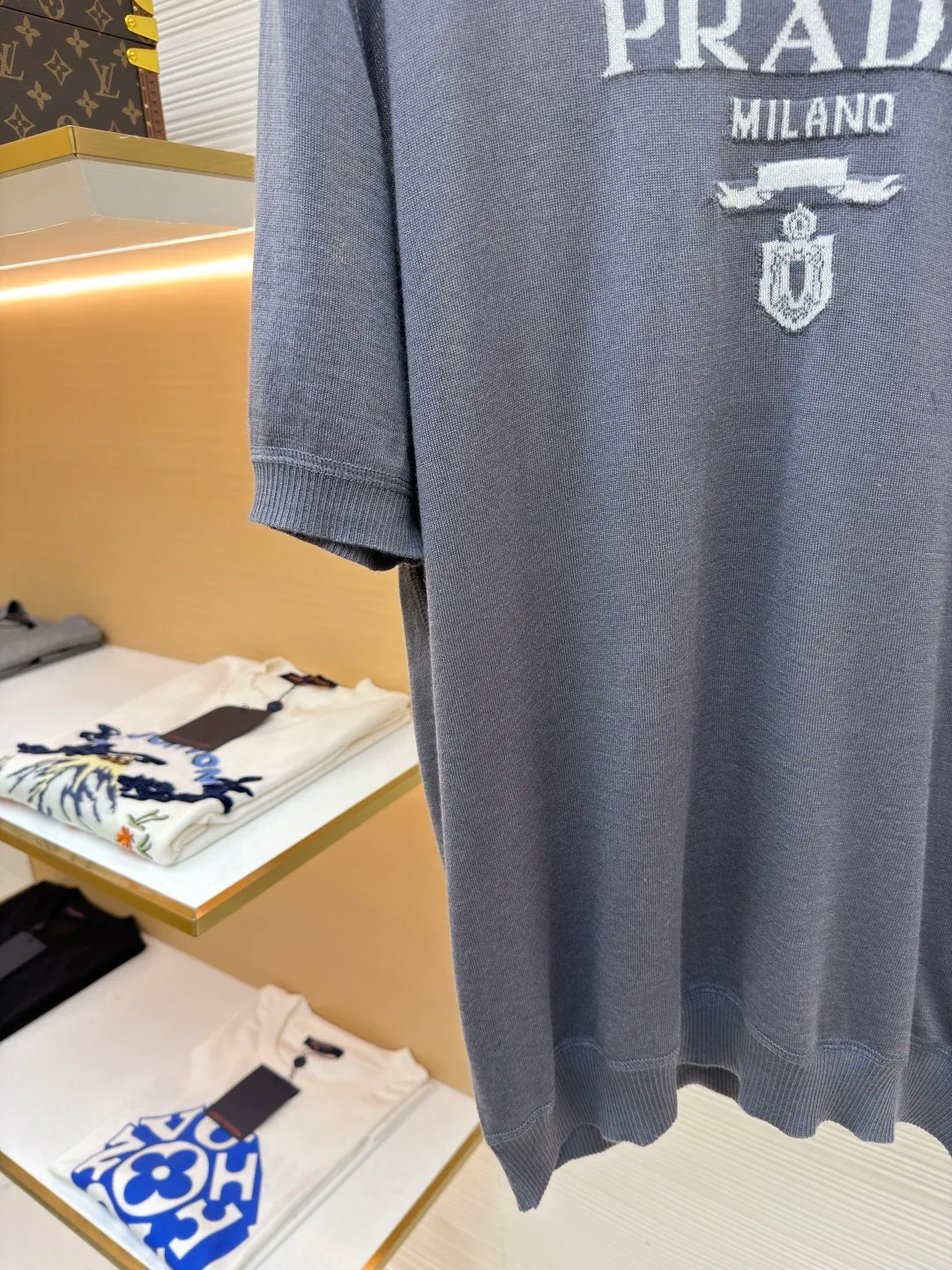 Prada classic LOGO jacquard wool round neck short sleeves ●Original version: purchased and developed by 11988 ●Item number: 1682515-A45 ●Fabric: wool fabric ●Technology: jacquard production ●Color: gray ●Version: fitted version ●Weight: about 150 grams ●Size: 46-48-50-52 ●Description: This PRADA gray knitted short-sleeve is woven with high-quality combed cotton threads. The body is made of vertical pit knitting technology. The texture is three-dimensional and elastic. It is soft and breathable when worn next to the skin. It has good drape and stiffness, and is not prone to pilling and deformation. The brand letters and badge pattern on the front of the garment are made with precision embroidery technology. The embroidery thread is made of imported high-gloss yarn. The stitches are dense and even, and the pattern is three-dimensional and clear. It forms a texture contrast with the knitted base to highlight the brand recognition. The neckline is a classic round neck design, with double-needle reinforced hemming technology and a customized threaded collar, which is durable and not easy to loosen. The cuffs and hem are ribbed in the same color. The overall cut is a loose silhouette. The stitching is straight and fine. The customized accessories and three standards are complete. The detailed craftsmanship shows the level of luxury. It is suitable for casual daily and light business wear scenarios. The overall wiring is straight and delicate, the fabric is comfortable and soft, and the color is consistent without color difference. It can be matched with the same style to create a fashionable look and control various occasions. Customized accessories, complete with three standards, same style for men and women!