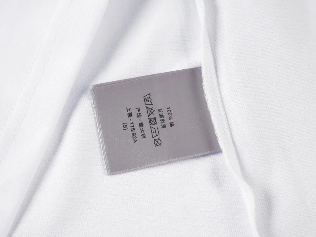 🅿️190 CD 2025 new style embroidered letter short sleeves. This T-shirt is from the DO AND KAWS limited series. Crafted from cotton jersey and embellished with DO AND KAWS embroidery, the Do logo is reinterpreted as a colorful snake. Wear it with the limited edition trousers for a refined look.  Cotton jersey fabric is a knitted fabric made of cotton fiber. The fabric has good moisture absorption and breathability. The softness and skin-friendly nature of the cotton fiber make the fabric feel comfortable to the touch. The fabric structure gives the fabric a certain degree of strength and stability, but its elasticity may be less than other complex weaving methods.  The tatami mat serves as the base for embroidery, ensuring its surface is flat and suitable for embroidery. The stitches of the embroidery are very tight, which makes the surface of the embroidery pattern smooth and delicate, and feels smooth to the touch. The use of bright silk threads for embroidery makes the pattern rich and full in color and has a strong visual impact.  Using a backstitch stitch, embroider along the edges of the design. The embroidery keeps the stitches tight and flat, and embroiders narrow strip-like graphics to ensure that the hemming effect shows a strong sense of line and three-dimensionality. CD / KAWS loose fit T-shirt Fabric: 12S fine cotton plain fabric / 310G Rib: 21S double yarn stretcher / 420G This T-shirt is from the DO AND KAWS limited series. Crafted from cotton jersey and embellished with DO AND KAWS embroidery, the Do logo is reinterpreted as a colorful snake. Wear it with the limited edition trousers for a refined look.  Cotton jersey fabric is a knitted fabric made of cotton fiber. The fabric has good moisture absorption and breathability. The softness and skin-friendly nature of the cotton fiber make the fabric feel comfortable to the touch. The fabric structure gives the fabric a certain degree of strength and stability, but its elasticity may be less than other complex weaving methods.  The tatami mat serves as the base for embroidery, ensuring its surface is flat and suitable for embroidery. The stitches of the embroidery are very tight, which makes the surface of the embroidery pattern smooth and delicate, and feels smooth to the touch. The use of bright silk threads for embroidery makes the pattern rich and full in color and has a strong visual impact.  Using a backstitch stitch, embroider along the edges of the design. The embroidery keeps the stitches tight and flat, and embroiders narrow strip-like graphics to ensure that the hemming effect shows a strong sense of line and three-dimensionality. Size: XS S M L