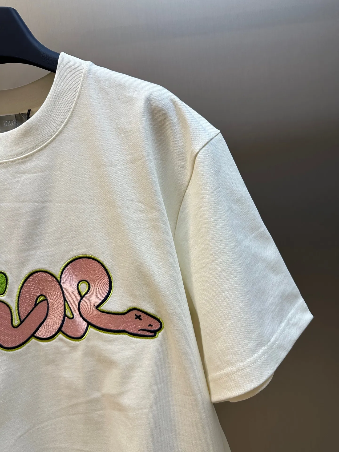 🅿️330 Dior Year of the Snake co-branded bloom-dyed short-sleeves are made of 21s double yarn cotton plain weave. Weighing 320g, it is equipped with 21 pairs of fine cotton yarns and 1*1 horizontal machine woven threads. The front and rear hems are printed with digital direct-injection printing, with large-size patterns throughout.  The front panel is embroidered with a Tajima embroidery machine imported from Japan. The number of embroidery stitches reaches 130,000. The thread color is matched with satin patch to increase stiffness to avoid shifting during the embroidery process. The three-layer embroidery method of short-needle tatami is matched with the new Year of Snake co-branded hangtag size: xs s m l