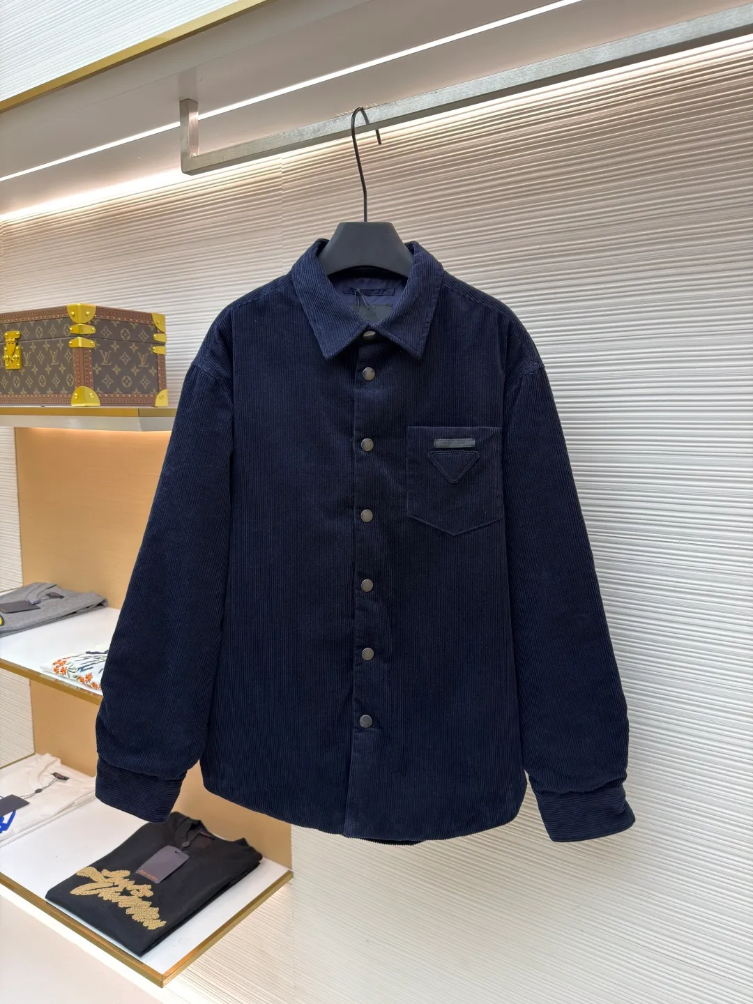Prada pocket triangle logo corduroy cotton jacket ●Original version: Purchased and developed for 16999 ●Item number: 1681386-B80 ●Fabric: corduroy fabric ●Technology: made on positioning cutting machine ●Color: navy ●Version: fitted version ●Weight: about 820 grams ●Size: S-M-L-XL ●Description: This item is made of high-quality corduroy fabric, and the main tone of dark blue presents a retro texture. It has a lapel design and a metal button placket, which is classic and tool-style. The single patch pocket on the front chest is decorated with the brand's iconic triangle logo, which presents a three-dimensional structure through precision sewing; the corduroy fabric has been specially washed to give it a soft and aged texture, with a soft touch and clear texture. In terms of sewing process, the seams are neatly and firmly routed, and the buttons are made of high-quality metal material, which is durable. From fabric washing to detail decoration, every process pays attention to the presentation of retro style, integrating workwear elements with retro corduroy technology to present a single product that is both practical and stylish. The overall wiring is straight and delicate, the fabric is comfortable and soft, and the color is consistent without color difference. It can be matched with the same style to create a fashionable look and control various occasions. Customized accessories, complete with three standards, same style for men and women!