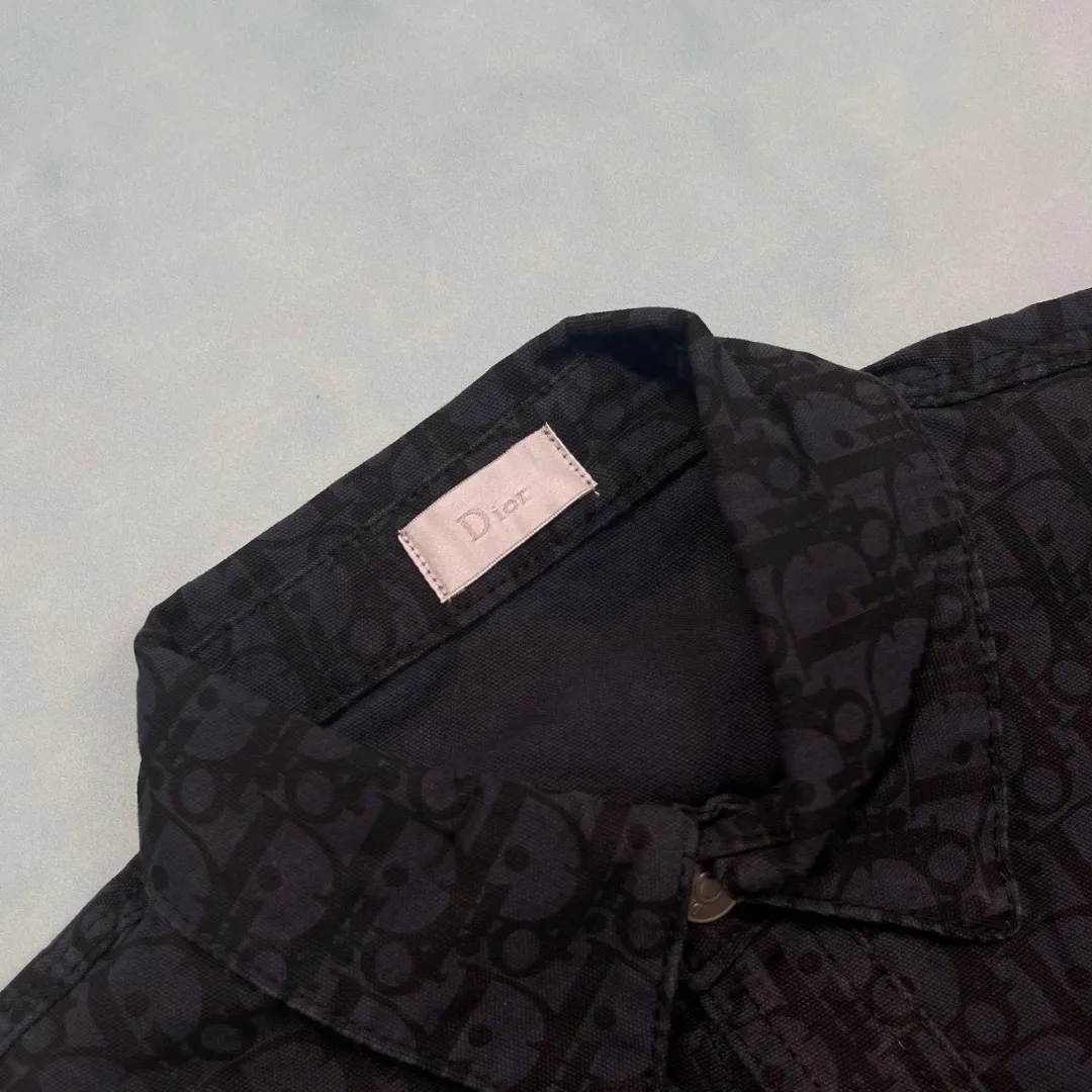 🅿️310 🔘Model No.-DR202 🔘Dior𝐃𝐨𝐢𝐫 CD presbyopic dark pattern jacquard denim long-sleeved shirt* This is really amazing, full of craftsmanship details! It uses 100% custom-dyed pure cotton denim, with black as the base tone, and the length of the warp and weft yarns of the space dyeing are exactly the same as the original. The all-over discharge dyeing process, as well as positioning cutting and pattern sewing, are ultra-fine. The texture is thick, with strong twill texture and clear lines. After special washing process, it feels soft to the touch. The button placket is silver-plated and has I-shaped buttons engraved with the logo. The hardware accessories are super exquisite. The three-label auxiliary materials are complete, including the Nissan Triangle landmark and the customized original washing water label. This shirt perfectly combines the luxurious style of Dior with the casual style of denim. Whether worn alone or in combination, it can easily achieve a sense of fashion. It is a treasured item to enhance your dressing taste. The matching suggestions are as follows: Advanced workplace style: Wear a white slim-fitting inner layer, black straight suit pants, a pair of black high heels, and this Dior denim shirt. Tuck the hem of the shirt into the pants. It is smart yet elegant, suitable for workplace commuting. Trendy street style: Wear a colorful printed T-shirt underneath, a pair of ripped jeans, and a pair of high-top sneakers, such as Vans classics. Tie a Dior denim shirt casually around your waist to instantly create a street trend. Casual holiday style: Wear a pair of light-colored linen wide-leg pants on the lower body, a pair of flat sandals on the feet, and wear this denim shirt open. You can choose a simple camisole underneath. Wear it like this when going on vacation, which is comfortable and fashionable.  Size: S M L (46.48.50) Color: Navy blue