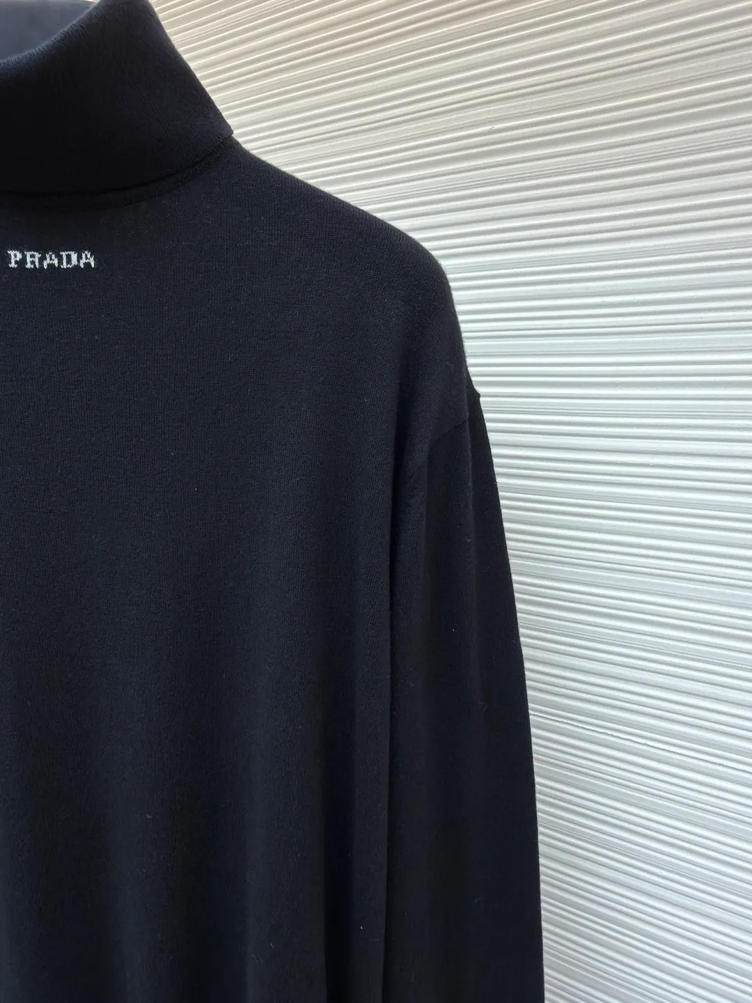 Prada jacquard turtleneck sweater ●Original version: Purchased and developed for 13600 ●Item number: 1681364-A75 ●Material: mercerized worsted wool fabric ●Technology: jacquard production ●Color: black ●Version: fitted version ●Weight: about 235 grams ●Size: 46-48-50-52 ●Description: Custom-woven mercerized worsted wool, soft and delicate, comfortable and close to the skin, with pure and clean white as the main color Self-sufficient, restrained and layered, self-evident elegance. The black PRADA logo forms a low-key dialogue with the soft sheen of white wool. It is accurately anchored under the collarbone at the visual golden section. It interprets PRADA's brand philosophy of minimalism and luxury. With the turtleneck version as the core, functional warmth is sublimated into aesthetic expression. Less is more. With an inclusive attitude, it becomes the invisible base of all your looks. Made of jacquard machine imported from Germany. Precisely control the arrangement and interweaving of yarns. Carefully interwoven on the loom. Prada logo jacquard artistic pattern inlay makes the fabric more vivid and three-dimensional, and the garment washing water is softened and deodorized using professional washing equipment and specific detergents to deeply clean and deodorize the clothes to improve the feel and appearance of the clothes. The overall wiring is straight and delicate, the fabric is comfortable and soft, and the color is consistent without color difference. It can be matched with the same style to create a fashionable look, and can be used in various occasions. Customized accessories, complete with three standards, the same style for men and women.