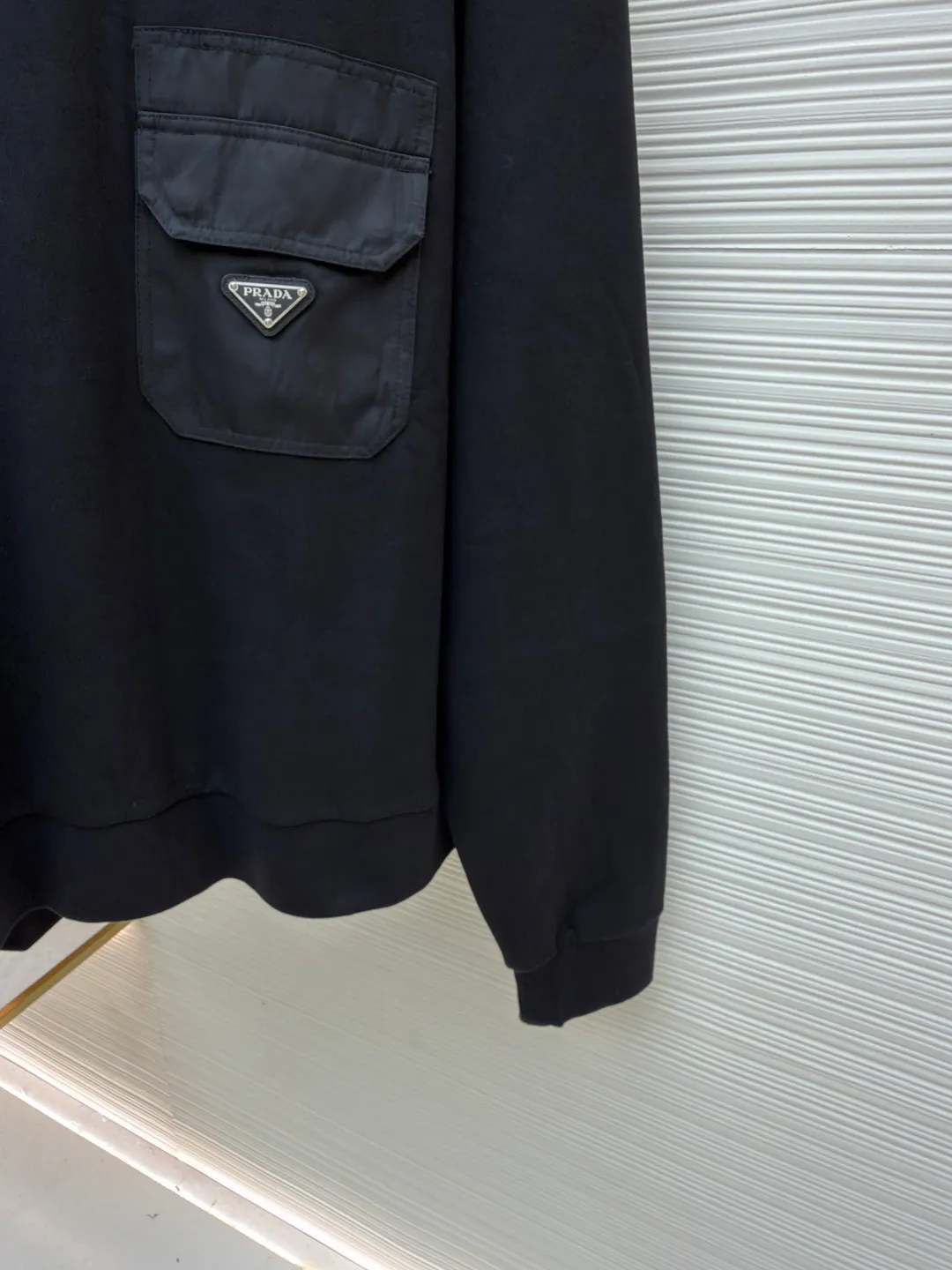 Prada triangle logo nylon sweatshirt ●Original version: Purchased and developed for 14100 ●Item number: 1680849-A45 ●Fabric: nylon woven fabric ●Technology: washed production ●Version: fitted version ●Weight: about 705 grams ●Size: S-M-L-XL ●Description: Customized 330 Clandy double-sided and nylon woven fabric, soft and delicate, comfortable and close to the skin, iconic enameled triangle metal logo embellishments on the front Integrated with Re-Nylon nylon fabric for sublimation, the drape created by nylon and the exquisite small pocket design highlight quality and style, revealing a flexible and relaxed beauty. It is a picture of walking in the city, weaving a symphony of dreams and reality. The imported special machine is used to position the "Prada triangle mark" with infrared rays for more accurate positioning. The strong-knot fabrics have been washed and have a better hand feel and texture. It is not easy to deform, not easy to shrink, not easy to fade, and maintains long-term beauty. The overall wiring is straight and delicate, the fabric is comfortable and soft, and the color is consistent without color difference. It can be matched with the same style to create a fashionable look and control various occasions. Customized accessories, complete with three standards, same style for men and women!