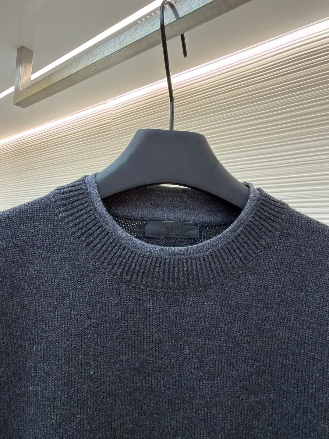 Prada round neck rib knitted cuffs and hem logo sweater ●Original version: Purchased and developed by 13114 ●Item number: 1682312-A90 ●Fabric: wool fabric ●Technology: knitted ●Color: gray ●Version: fitted version ●Weight: about 765 grams ●Size: S-M-L-XL ●Description: This Prada knitted round-neck top is woven with high-count blended wool yarn imported from Italy. It is treated with a double-ply yarn process to increase the yarn's toughness by 30%, while giving the fabric a delicate matte texture and a soft and skin-friendly touch. The main body of the garment uses a 12-needle four-flat knitting method and is designed with vertical rib texture, which not only ensures a stiff silhouette and is not easily deformed, but also allows for freedom of stretching while wearing. The neckline, cuffs and hem adopt reinforced ribbing technology, and the elastic closing is formed by precise jacquard using a computerized flat knitting machine, effectively preventing loose and curling edges. The brand metal nameplate is embedded in the side seam, which is hand-polished and then seamlessly sewn together. The splicing parts of the body are all made of concealed seam technology, making the overall lines simple and smooth. Every detail demonstrates the brand's exquisite clothing craftsmanship and strict quality control. The overall wiring is straight and delicate, the fabric is comfortable and soft, and the color is consistent without color difference. It can be matched with the same style to create a fashionable look and control various occasions. Customized accessories, complete with three standards, same style for men and women!