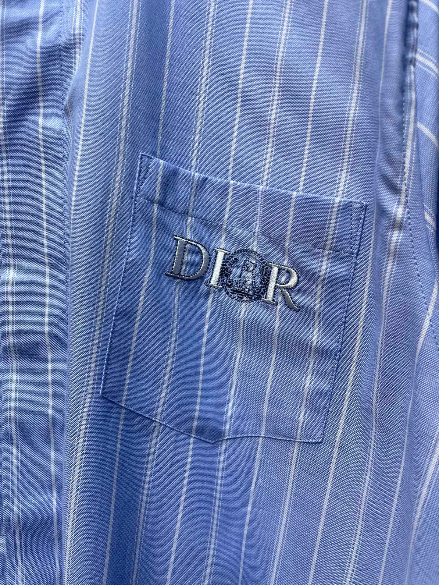 🅿️480 25ss🌟【Top Replica】The new shirt has both modern style and traditional beauty. Crafted from blue and white oxford cloth, it's finished with a striped pattern that showcases the signatures of this season's and hylton nel collaboration. A patch pocket on the chest and hidden button closure complete the design. Can be worn with everyday clothing. Code number: 39 40 41 42