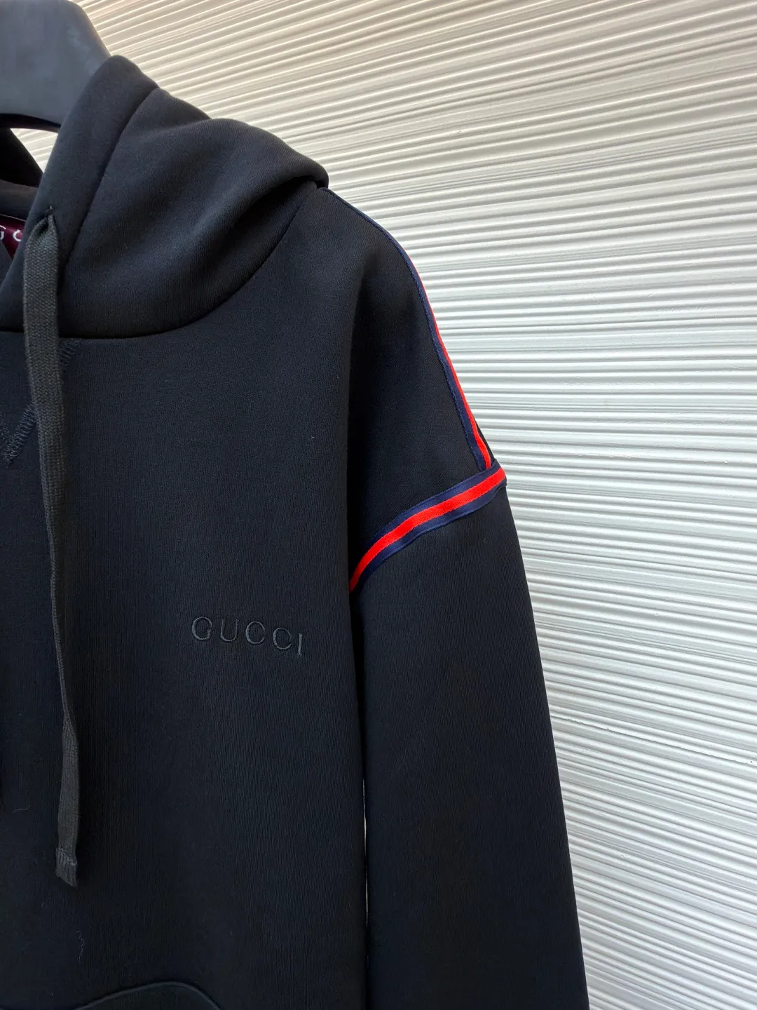 Gucci black webbing hooded sweatshirt ●Item number: 1681424-B10 ●Material: cotton terry fabric ●Technology: embroidery production ●Color: black ●Version: fitted version ●Weight: about 695 grams ●Size: S-M-L ●Description: This sweatshirt is made of high-density waffle velvet fabric, which feels thick and has good warmth retention. The hooded design adopts three-dimensional tailoring and drawstring technology. The hood is stiff and can be freely adjusted for tightness. The red and blue webbing on the shoulders uses inlay sewing technology to form a sharp visual contrast with the black fabric, and the lines are smooth and firm. The brand logo on the chest uses high-density embroidery technology, and the letter texture is delicate and closely adheres to the fabric. The kangaroo pocket is made of one-piece molding technology, with flat edges and convenient storage. The cuffs and hem ribs are made of high-elastic knitting technology, which closely fits the body and has excellent elasticity. The overall cut is a loose, dropped-shoulder version, and the multi-piece structure is spliced ​​to create a casual and trendy wearing effect, while ensuring comfort and freedom during movement. It is a fashionable item that combines the brand's classic elements with casual sweatshirt technology, and has both texture and practicality. The overall wiring is straight and delicate, the fabric is comfortable and soft, and the color is consistent without color difference. It can be matched with the same style to create a fashionable look and control various occasions. Customized accessories, complete with three standards, same style for men and women!