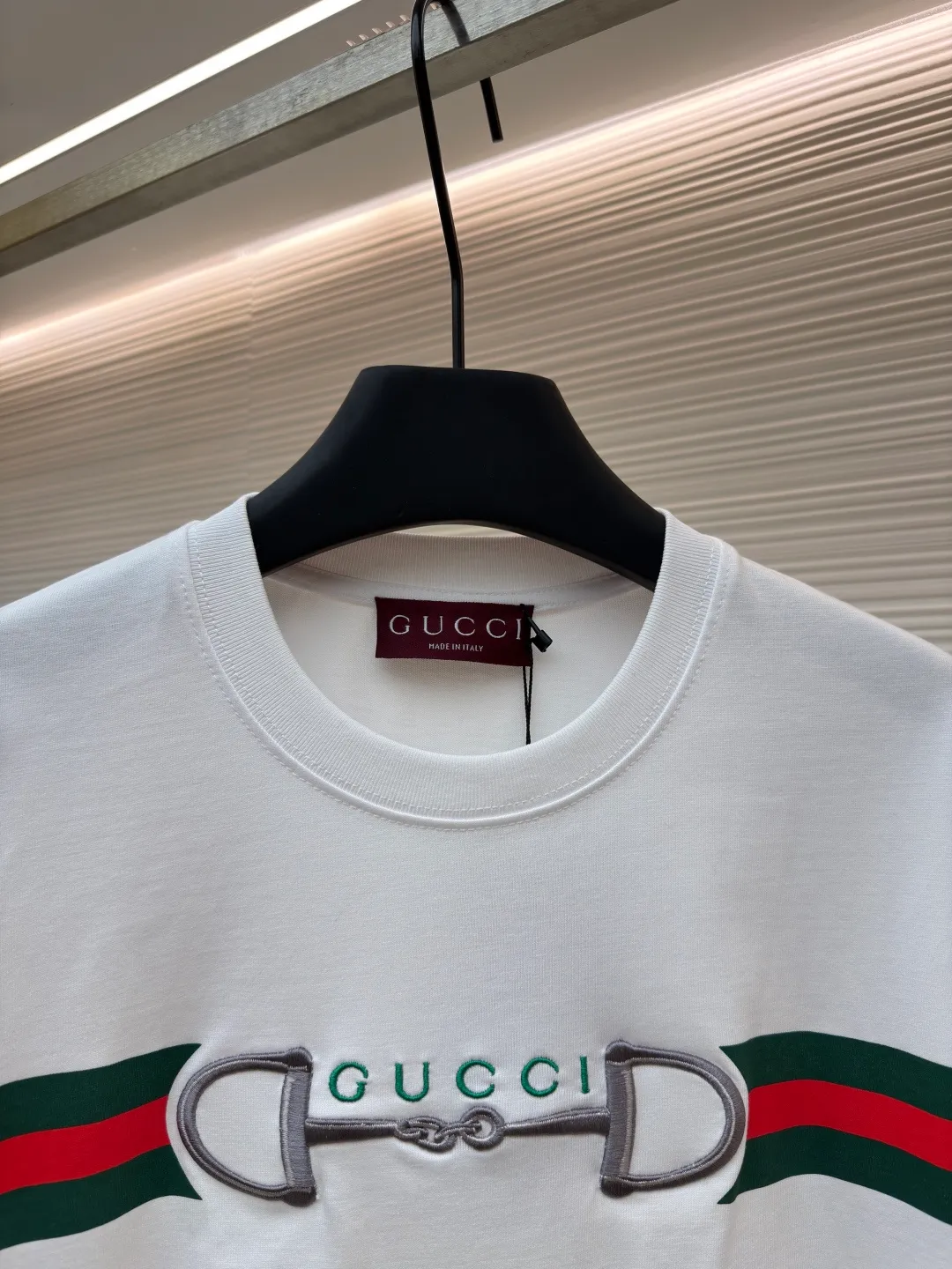 Gucci Lock Round Neck Short Sleeves ●Original version: Purchased and developed by 3031 ●Item number: 1682127-A05 ●Fabric: fine velvet knitted cotton fabric ●Technology: embroidery production ●Color: white ●Version: fitted version ●Weight: about 280 grams ●Size: XS-S-M-L ●Description: Made of 15S special woven compact cotton fine velvet knitted fabric with a weight of 230g/㎡; paired with 32S high count and high weight 1x1 rib, with a weight of 340g/㎡. Ribbing is used on the collar to ensure excellent elastic recovery and deformation resistance of the collar. The fabric uses compact spinning technology to effectively reduce yarn hairiness, making the fabric structure tighter, the surface smoother, and the pilling resistance better. The weight of 230g is medium to heavy, which gives the T-shirt good stiffness and drape, and is not easy to collapse, ensuring the texture of high-end ready-to-wear. The fine velvet knitted fabric has been lightly brushed or raised, giving it a softer, waxier skin-friendly feel than ordinary plain cotton. Environmentally friendly elastic glue printing uses water-based environmentally friendly slurry and polymer cross-linking technology to make the pattern have excellent elasticity and can expand and contract simultaneously with the fabric without cracking. The printing layer has a matte texture, is soft and smooth to the touch, and does not have the hardening feel of traditional offset printing, while maintaining the breathability of the fabric. It has strong color coverage, is washable and wear-resistant, and takes into account both visual performance and wearing comfort. Core-covered three-dimensional embroidery is made by pre-inserting a foam core material under the high-density embroidery layer as a filling base, and then fully covering it with embroidery threads. The process can create a three-dimensional pattern with highly pronounced convexities and rounded and full edges, and the visual effect is extremely impactful. The overall wiring is straight and delicate, the fabric is comfortable and soft, and the color is consistent without color difference. It can be matched with the same style to create a fashionable look and control various occasions. Customized accessories, complete with three standards, same style for men and women!