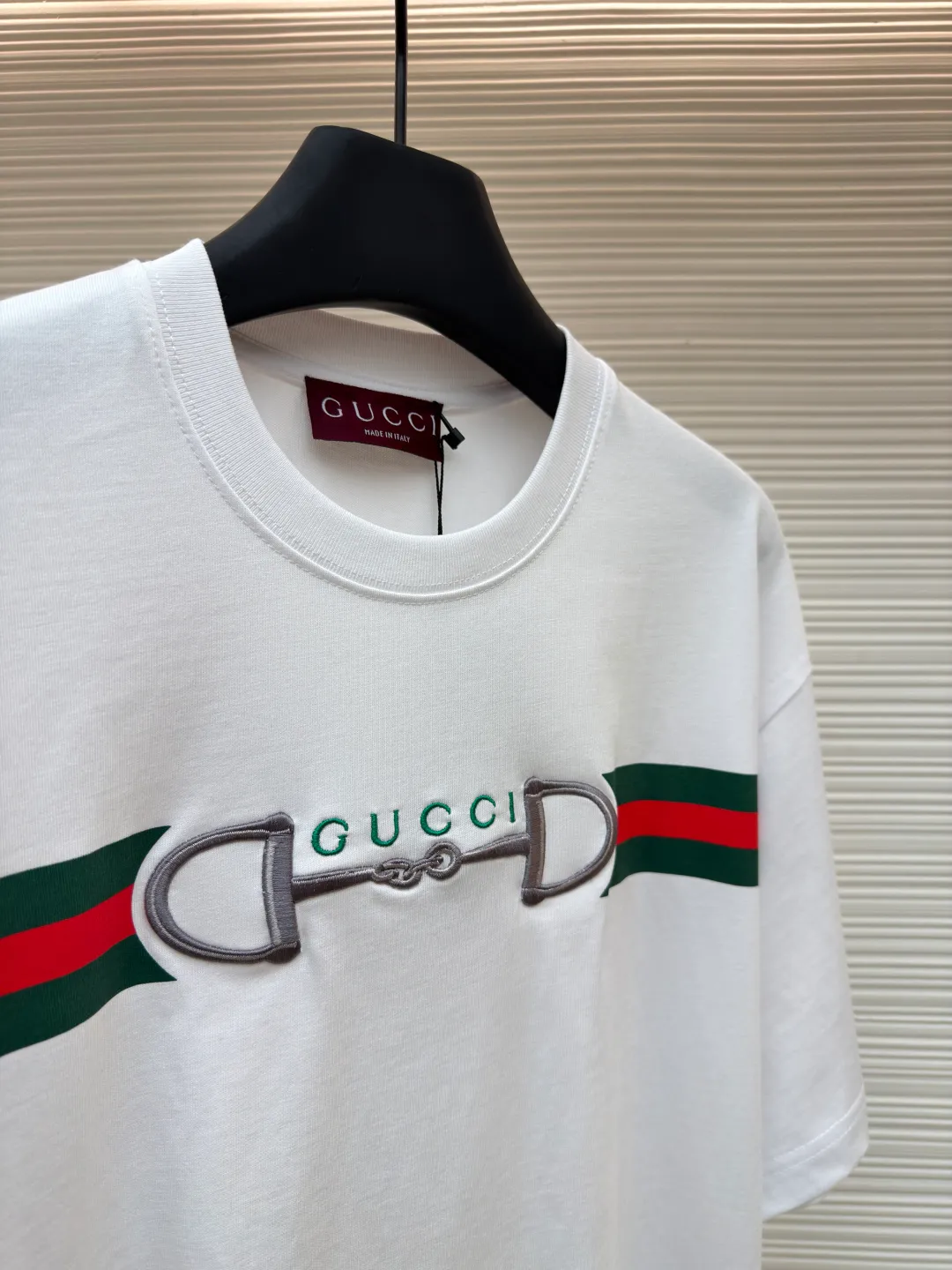 Gucci Lock Round Neck Short Sleeves ●Original version: Purchased and developed by 3031 ●Item number: 1682127-A05 ●Fabric: fine velvet knitted cotton fabric ●Technology: embroidery production ●Color: white ●Version: fitted version ●Weight: about 280 grams ●Size: XS-S-M-L ●Description: Made of 15S special woven compact cotton fine velvet knitted fabric with a weight of 230g/㎡; paired with 32S high count and high weight 1x1 rib, with a weight of 340g/㎡. Ribbing is used on the collar to ensure excellent elastic recovery and deformation resistance of the collar. The fabric uses compact spinning technology to effectively reduce yarn hairiness, making the fabric structure tighter, the surface smoother, and the pilling resistance better. The weight of 230g is medium to heavy, which gives the T-shirt good stiffness and drape, and is not easy to collapse, ensuring the texture of high-end ready-to-wear. The fine velvet knitted fabric has been lightly brushed or raised, giving it a softer, waxier skin-friendly feel than ordinary plain cotton. Environmentally friendly elastic glue printing uses water-based environmentally friendly slurry and polymer cross-linking technology to make the pattern have excellent elasticity and can expand and contract simultaneously with the fabric without cracking. The printing layer has a matte texture, is soft and smooth to the touch, and does not have the hardening feel of traditional offset printing, while maintaining the breathability of the fabric. It has strong color coverage, is washable and wear-resistant, and takes into account both visual performance and wearing comfort. Core-covered three-dimensional embroidery is made by pre-inserting a foam core material under the high-density embroidery layer as a filling base, and then fully covering it with embroidery threads. The process can create a three-dimensional pattern with highly pronounced convexities and rounded and full edges, and the visual effect is extremely impactful. The overall wiring is straight and delicate, the fabric is comfortable and soft, and the color is consistent without color difference. It can be matched with the same style to create a fashionable look and control various occasions. Customized accessories, complete with three standards, same style for men and women!