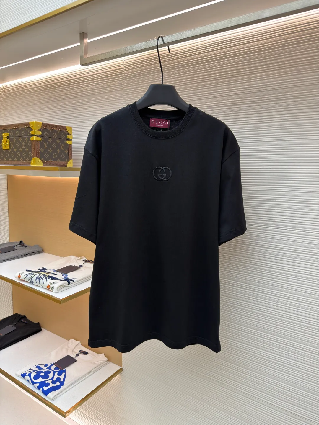 Gucci Double G embroidered round neck short sleeves ●Original version: Purchased and developed for 5300 ●Item number: 1682500-X90 ●Fabric: fine velvet knitted cotton fabric ●Technology: embroidery production ●Color: black ●Version: fitted version ●Weight: about 295 grams ●Size: S-M-L-XL ●Description: Made of 15S special woven compact cotton fine velvet knitted fabric with a weight of 230g/㎡; paired with 32S high count and high weight 1x1 rib, with a weight of 340g/㎡. Ribbing is used on the collar to ensure excellent elastic recovery and deformation resistance of the collar. The fabric uses compact spinning technology to effectively reduce yarn hairiness, making the fabric structure tighter, the surface smoother, and the pilling resistance better. The weight of 230g is medium to heavy, which gives the T-shirt good stiffness and drape, and is not easy to collapse, ensuring the texture of high-end ready-to-wear. The fine velvet knitted fabric has been lightly brushed or raised, giving it a softer, waxier skin-friendly feel than ordinary plain cotton. Three-dimensional stitch embroidery is an embroidery process that uses high-density linear stitches to be closely arranged to form raised lines. The core is to use thicker embroidery thread, and the stitches are continuous and even without gaps. It naturally produces a raised height of 1-2 mm, making the edges of the pattern clear and sharp, and the touch feeling full and solid. The overall wiring is straight and delicate, the fabric is comfortable and soft, and the color is consistent without color difference. It can be matched with the same style to create a fashionable look and control various occasions. Customized accessories, complete with three standards, same style for men and women!