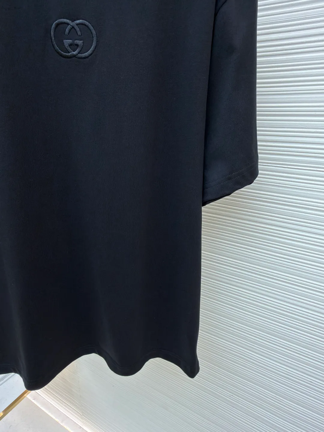 Gucci Double G embroidered round neck short sleeves ●Original version: Purchased and developed for 5300 ●Item number: 1682500-X90 ●Fabric: fine velvet knitted cotton fabric ●Technology: embroidery production ●Color: black ●Version: fitted version ●Weight: about 295 grams ●Size: S-M-L-XL ●Description: Made of 15S special woven compact cotton fine velvet knitted fabric with a weight of 230g/㎡; paired with 32S high count and high weight 1x1 rib, with a weight of 340g/㎡. Ribbing is used on the collar to ensure excellent elastic recovery and deformation resistance of the collar. The fabric uses compact spinning technology to effectively reduce yarn hairiness, making the fabric structure tighter, the surface smoother, and the pilling resistance better. The weight of 230g is medium to heavy, which gives the T-shirt good stiffness and drape, and is not easy to collapse, ensuring the texture of high-end ready-to-wear. The fine velvet knitted fabric has been lightly brushed or raised, giving it a softer, waxier skin-friendly feel than ordinary plain cotton. Three-dimensional stitch embroidery is an embroidery process that uses high-density linear stitches to be closely arranged to form raised lines. The core is to use thicker embroidery thread, and the stitches are continuous and even without gaps. It naturally produces a raised height of 1-2 mm, making the edges of the pattern clear and sharp, and the touch feeling full and solid. The overall wiring is straight and delicate, the fabric is comfortable and soft, and the color is consistent without color difference. It can be matched with the same style to create a fashionable look and control various occasions. Customized accessories, complete with three standards, same style for men and women!
