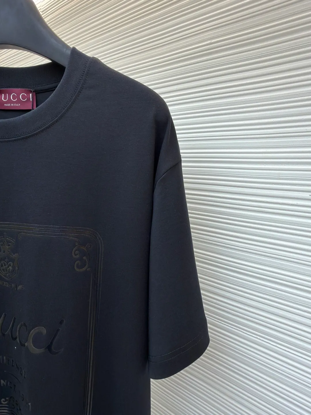 Gucci Buddha City printed round neck short sleeves ●Original version: purchased and developed by 5039 ●Item number: 1682281-A00 ●Fabric: soft knitted cotton fabric ●Technology: Glue printing production ●Color: black ●Version: fitted version ●Weight: about 235 grams ●Size: XS-S-M-L ●Description: This product is made of 60-count single-yarn double-sided knitted cotton with a weight of 170g/㎡; the neckline and other parts are matched with 32-count double-yarn ribbing. The high weight ensures a stable collar shape. 60 counts is an extremely high count, which means the yarn is extremely fine, which directly gives the fabric an extraordinary delicate, silky and soft touch. The front and back sides of the double-sided fabric have the same texture, which is uniform, thin and elastic. The weight of 170g is lightweight, ensuring the T-shirt is extremely light, breathable and drapey. It is almost invisible when worn and is very suitable for early spring. The color of the fabric is soft and high-end, which further enhances the exquisite texture of the fabric. The direct expression of the printing collection elements uses the environmentally friendly elastic thick plate bright glue printing process to place such a three-dimensional, bright, and highly present slogan printing on the simple sweater. This is a high-end special printing technology. Thick plate means that the slurry is accumulated thickly, which can form an obvious three-dimensional effect; after the bright slurry is cured, the surface will show a high-gloss glossy effect; the slurry itself is elastic and can stretch with the fabric. The special environmentally friendly elastic bright slurry is transferred through thick coating on the screen and then solidified at high temperature. Create a brand slogan pattern with significant 3D raised texture, mirror-like luster, and strong stretch resistance. To the touch, the pattern area has obvious stiff bulges and a smooth lacquered surface, which forms a strong contrast with the extremely soft fabric base and has a strong visual impact. The overall wiring is straight and delicate, the fabric is comfortable and soft, and the color is consistent without color difference. It can be matched with the same style to create a fashionable look and control various occasions. Customized accessories, complete with three standards, same style for men and women!