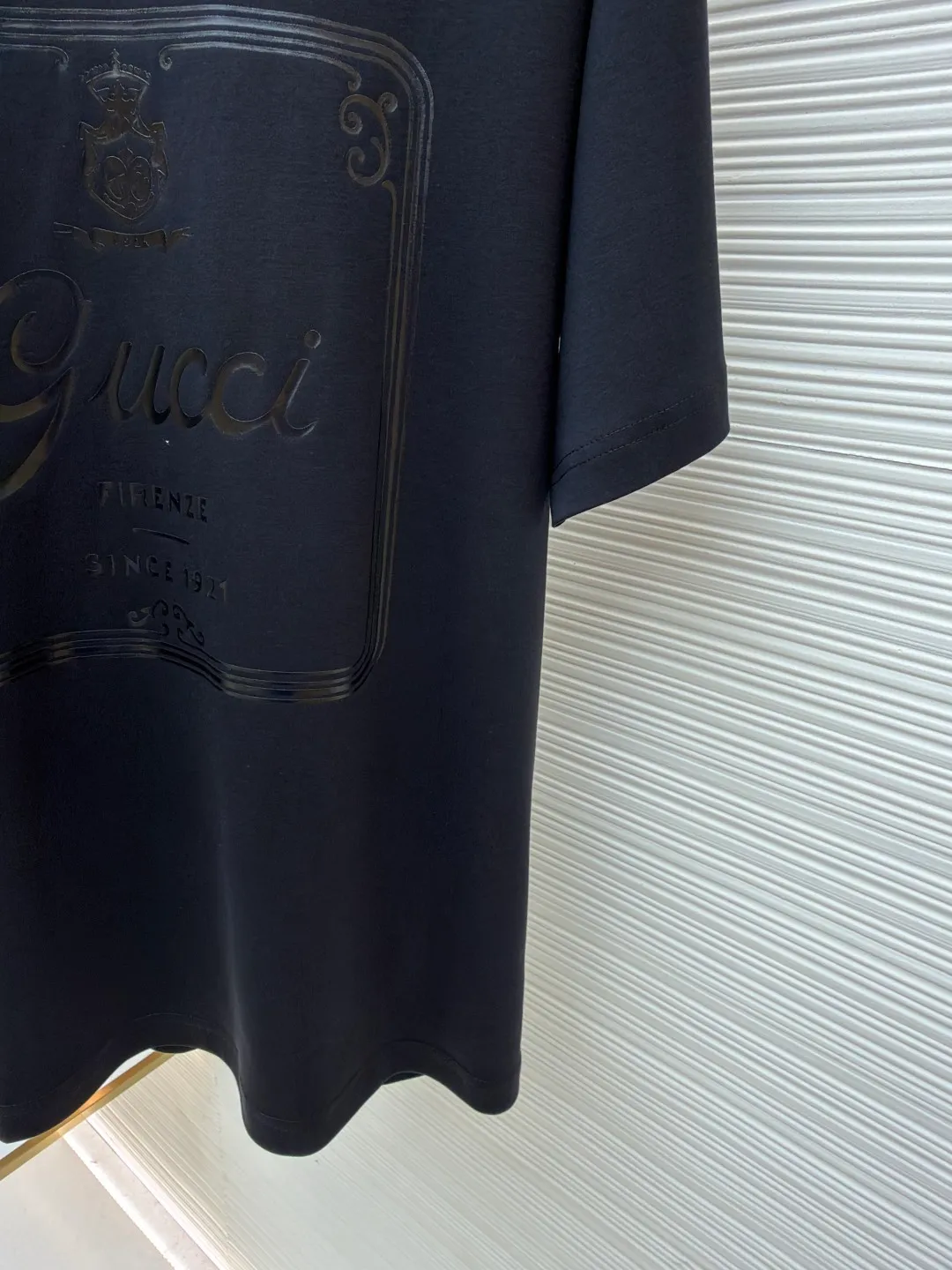 Gucci Buddha City printed round neck short sleeves ●Original version: purchased and developed by 5039 ●Item number: 1682281-A00 ●Fabric: soft knitted cotton fabric ●Technology: Glue printing production ●Color: black ●Version: fitted version ●Weight: about 235 grams ●Size: XS-S-M-L ●Description: This product is made of 60-count single-yarn double-sided knitted cotton with a weight of 170g/㎡; the neckline and other parts are matched with 32-count double-yarn ribbing. The high weight ensures a stable collar shape. 60 counts is an extremely high count, which means the yarn is extremely fine, which directly gives the fabric an extraordinary delicate, silky and soft touch. The front and back sides of the double-sided fabric have the same texture, which is uniform, thin and elastic. The weight of 170g is lightweight, ensuring the T-shirt is extremely light, breathable and drapey. It is almost invisible when worn and is very suitable for early spring. The color of the fabric is soft and high-end, which further enhances the exquisite texture of the fabric. The direct expression of the printing collection elements uses the environmentally friendly elastic thick plate bright glue printing process to place such a three-dimensional, bright, and highly present slogan printing on the simple sweater. This is a high-end special printing technology. Thick plate means that the slurry is accumulated thickly, which can form an obvious three-dimensional effect; after the bright slurry is cured, the surface will show a high-gloss glossy effect; the slurry itself is elastic and can stretch with the fabric. The special environmentally friendly elastic bright slurry is transferred through thick coating on the screen and then solidified at high temperature. Create a brand slogan pattern with significant 3D raised texture, mirror-like luster, and strong stretch resistance. To the touch, the pattern area has obvious stiff bulges and a smooth lacquered surface, which forms a strong contrast with the extremely soft fabric base and has a strong visual impact. The overall wiring is straight and delicate, the fabric is comfortable and soft, and the color is consistent without color difference. It can be matched with the same style to create a fashionable look and control various occasions. Customized accessories, complete with three standards, same style for men and women!