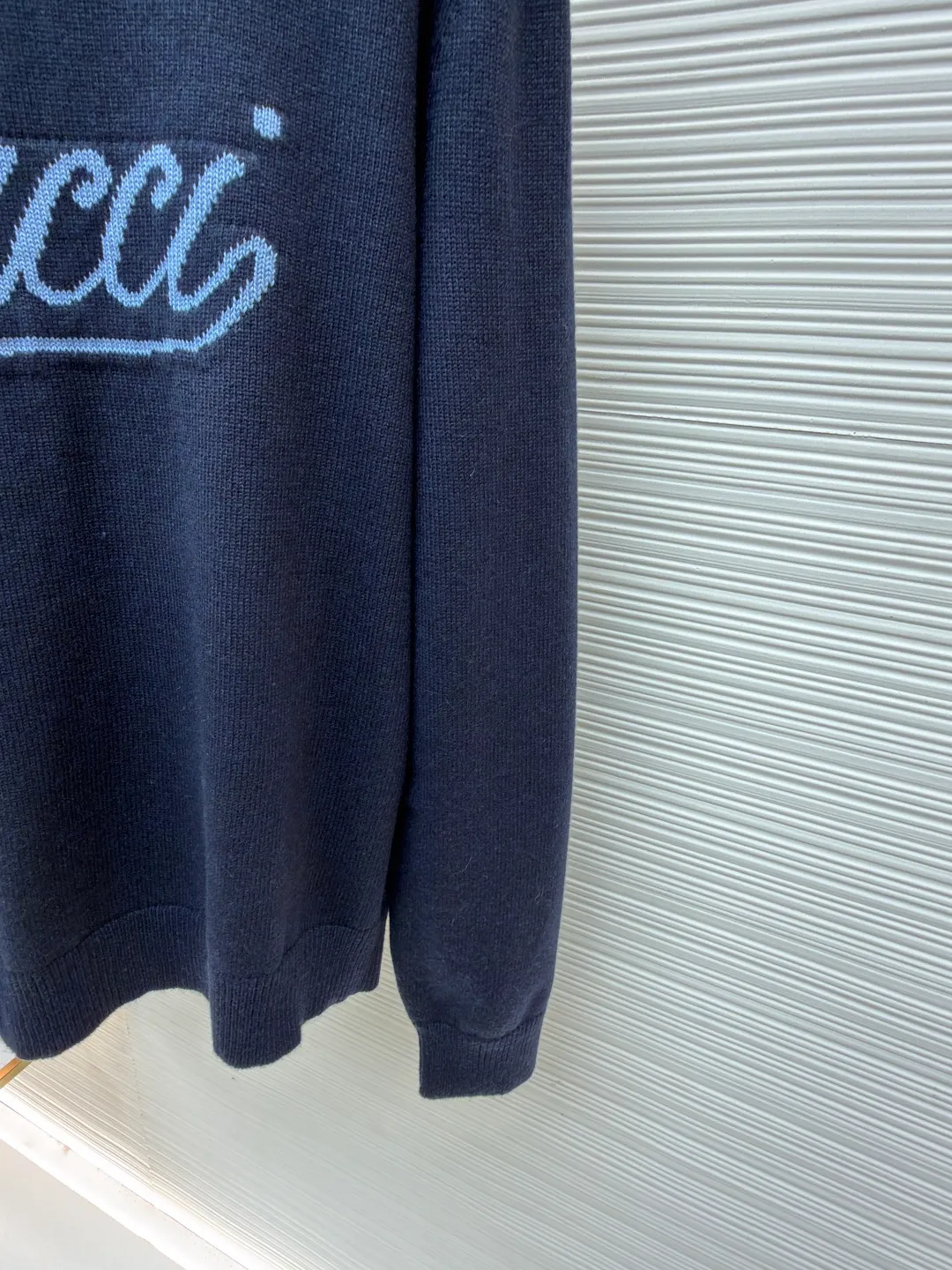 Gucci intarsia knitted wool crew neck sweater ●Original version: purchased and developed by 10024 ●Item number: 1681824-A85 ●Fabric: wool blended fabric ●Technology: knitted intarsia production ●Color: navy blue ●Version: fitted version ●Weight: about 540 grams ●Size: XS-S-M-L ●Description: This Gucci navy blue sweater is made of worsted wool blended fabric with fine flat stitch as the base, which is soft to the touch and has good warmth retention. The core logo of the garment uses contrasting jacquard technology: the light blue font is presented in a three-dimensional texture, and the strokes are smooth and delicate, forming a soft layer with the navy blue background, while retaining the recognition of the brand logo; the collar, cuffs and hem are all ribbed knitted structures, with elastic edges to ensure fit and durability. The body shape is cut with loose shoulders, and the stitching is neat without unnecessary threads. The jacquard texture and the base knitting are naturally connected, which not only reflects the fine workmanship of luxury items, but also makes it comfortable and casual for daily wear. The overall wiring is straight and delicate, the fabric is comfortable and soft, and the color is consistent without color difference. It can be matched with the same style to create a fashionable look and control various occasions. Customized accessories, complete with three standards, same style for men and women!