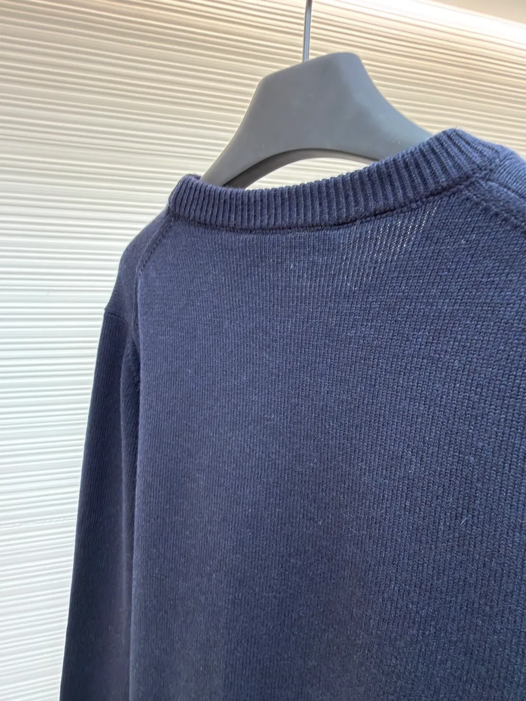 Gucci intarsia knitted wool crew neck sweater ●Original version: purchased and developed by 10024 ●Item number: 1681824-A85 ●Fabric: wool blended fabric ●Technology: knitted intarsia production ●Color: navy blue ●Version: fitted version ●Weight: about 540 grams ●Size: XS-S-M-L ●Description: This Gucci navy blue sweater is made of worsted wool blended fabric with fine flat stitch as the base, which is soft to the touch and has good warmth retention. The core logo of the garment uses contrasting jacquard technology: the light blue font is presented in a three-dimensional texture, and the strokes are smooth and delicate, forming a soft layer with the navy blue background, while retaining the recognition of the brand logo; the collar, cuffs and hem are all ribbed knitted structures, with elastic edges to ensure fit and durability. The body shape is cut with loose shoulders, and the stitching is neat without unnecessary threads. The jacquard texture and the base knitting are naturally connected, which not only reflects the fine workmanship of luxury items, but also makes it comfortable and casual for daily wear. The overall wiring is straight and delicate, the fabric is comfortable and soft, and the color is consistent without color difference. It can be matched with the same style to create a fashionable look and control various occasions. Customized accessories, complete with three standards, same style for men and women!