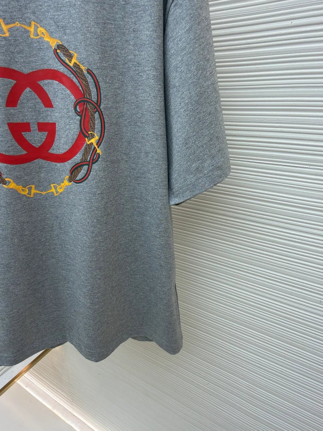 Gucci bridle webbing round neck short sleeves ●Original version: purchased and developed by 5270 ●Item number: 1682231-A00 ●Fabric: fine velvet knitted cotton fabric ●Technology: glue printing ●Color: gray ●Version: fitted version ●Weight: about 280 grams ●Size: XS-S-M-L ●Description: 5S special woven compact fine velvet knitted cotton, weight 230g/㎡; paired with 32S high count and weight 1x1 rib, weight 340g/㎡. Ribbing is used on the collar to ensure excellent elastic recovery and deformation resistance of the collar. The fabric adopts compact spinning technology in the spinning process, which significantly reduces yarn hairiness, making the fabric structure denser, the surface smoother, and the pilling resistance better; fine velvet knitted fabric means that the fabric has been lightly sanded or raised. It feels close to ultra-fine suede; it has a soft and waxy skin-friendly feel. The weight of 230g is medium to heavy, which gives the T-shirt good stiffness and drape, ensuring the texture of the garment and the silhouette that is not prone to collapse. The pattern adopts environmentally friendly elastic glue printing technology. The special environmentally friendly water-based elastic slurry is transferred to the surface of the fabric through a fine silk screen, and then baked and solidified at high temperature. Its elastic properties ensure that the printed pattern can stretch with the fabric without cracking, and has excellent durability; the printed area presents a semi-matte uniform coating effect with high color saturation. It feels soft to the touch and has no obvious film lumps, maintaining the original breathability and comfort of the fabric. The overall wiring is straight and delicate, the fabric is comfortable and soft, and the color is consistent without color difference. It can be matched with the same style to create a fashionable look and control various occasions. Customized accessories, complete with three standards, same style for men and women!