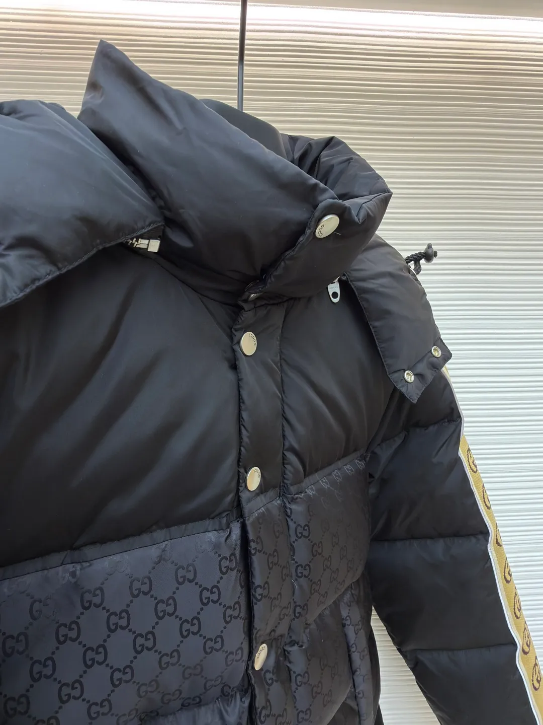 Gucci full-print webbing nylon down jacket ●Original version: purchased and developed by 10929 ●Item number: 1681831-C85 ●Fabric: goose down fabric ●Technology: mechanical down filling ●Color: black ●Version: fitted version ●Weight: about 1120 grams ●Size: 42-44-46-48-50 ●Description: This Gucci patchwork down jacket uses collision splicing technology: the body is made of high-density matte nylon, embossed with the brand's classic double G dark pattern, and heat-pressed shaping technology is used to ensure the three-dimensionality of the pattern; the shoulders and sleeves are made of glossy nylon fabric, with side webbing (full-print Double G logo). The webbing is connected to the body through precision sewing technology, and the edges are neatly seamed. It uses segmented down filling quilting to accurately control the amount of down filling according to areas, taking into account both warmth and style. The hood is designed with a metal adjustment buckle, the placket is closed with a metal snap button, and the cuffs and hem are elastic ribbed. The overall design is 3D cut, and the material contrast in the details echoes the logo, which not only retains brand recognition, but also enhances the comfort and functionality of wearing. The overall wiring is straight and delicate, the fabric is comfortable and soft, and the color is consistent without color difference. It can be matched with the same style to create a fashionable look and control various occasions. Customized accessories, complete with three standards, same style for men and women!